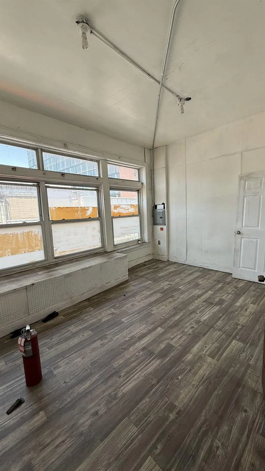Empty room with dark wood-style flooring and radiator heating unit Empty room with dark wood-style flooring and radiator heating unit