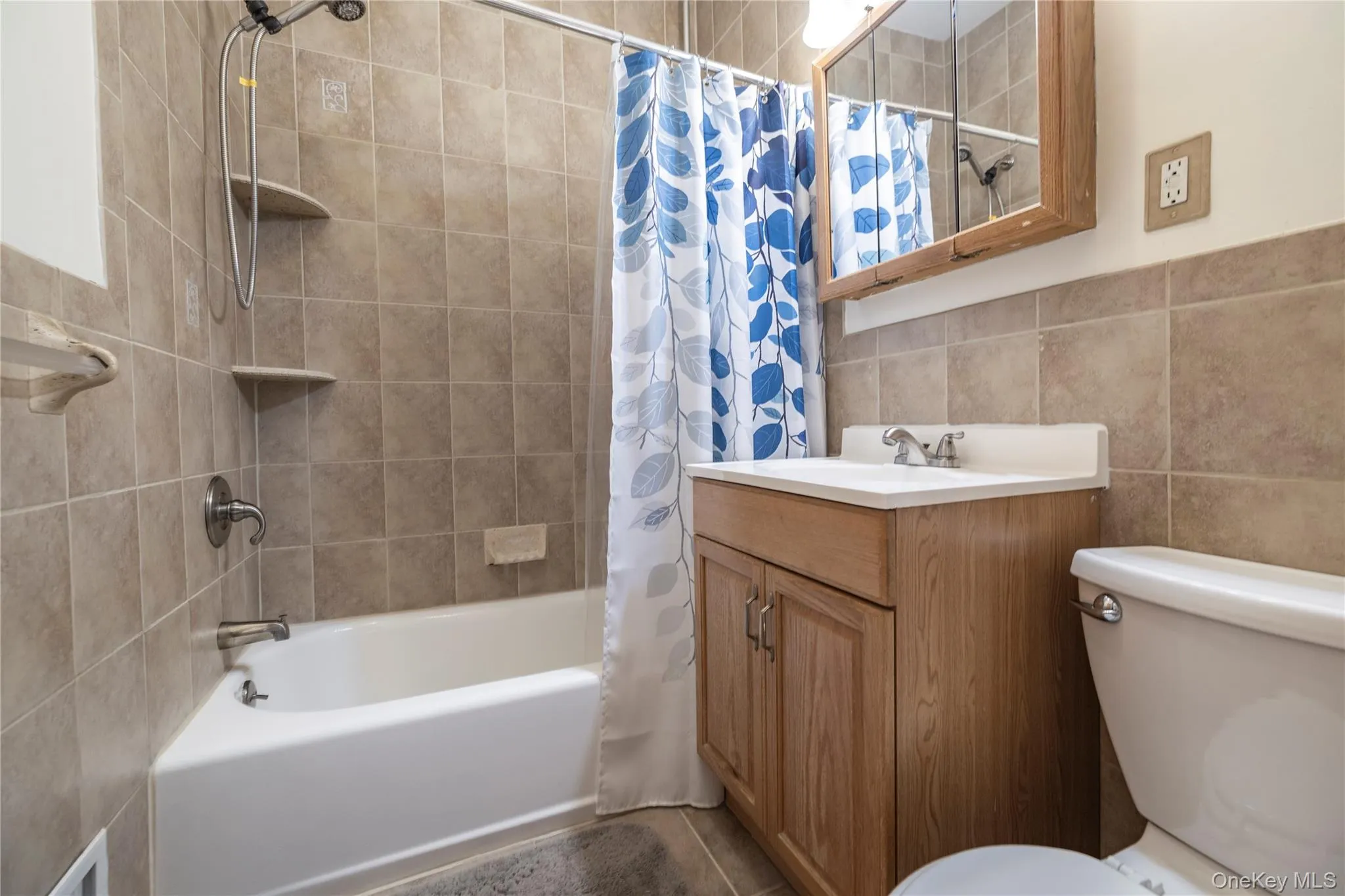 HALLWAY Bathroom featuring tile walls, shower / tub combo with curtain, and vanity HALLWAY Bathroom featuring tile walls, shower / tub combo with curtain, and vanity