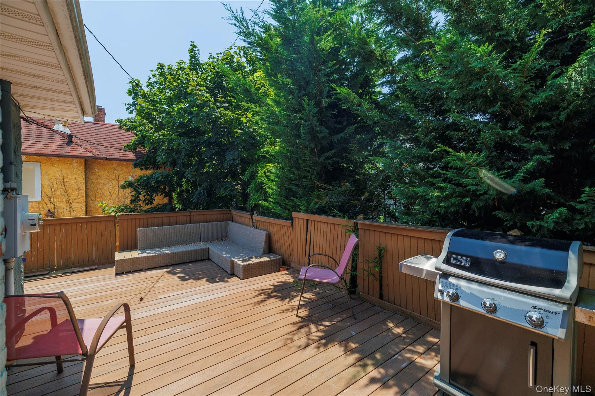 Wooden terrace featuring an outdoor living space and a grill Wooden terrace featuring an outdoor living space and a grill