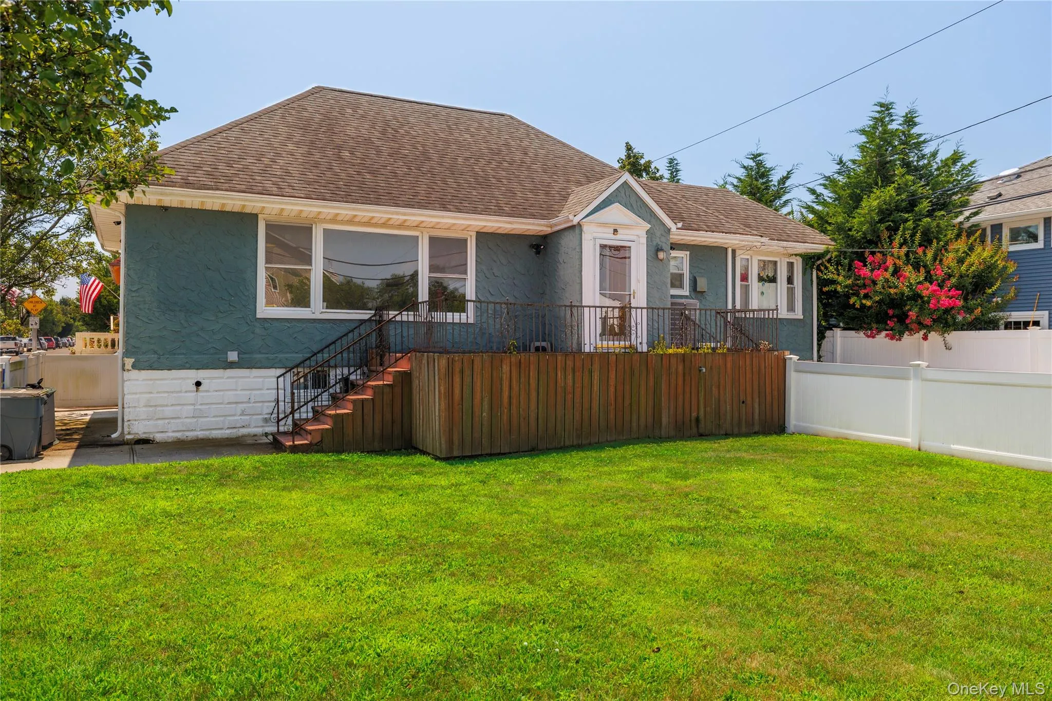View of front facade featuring a shingled roof and stairway View of front facade featuring a shingled roof and stairway