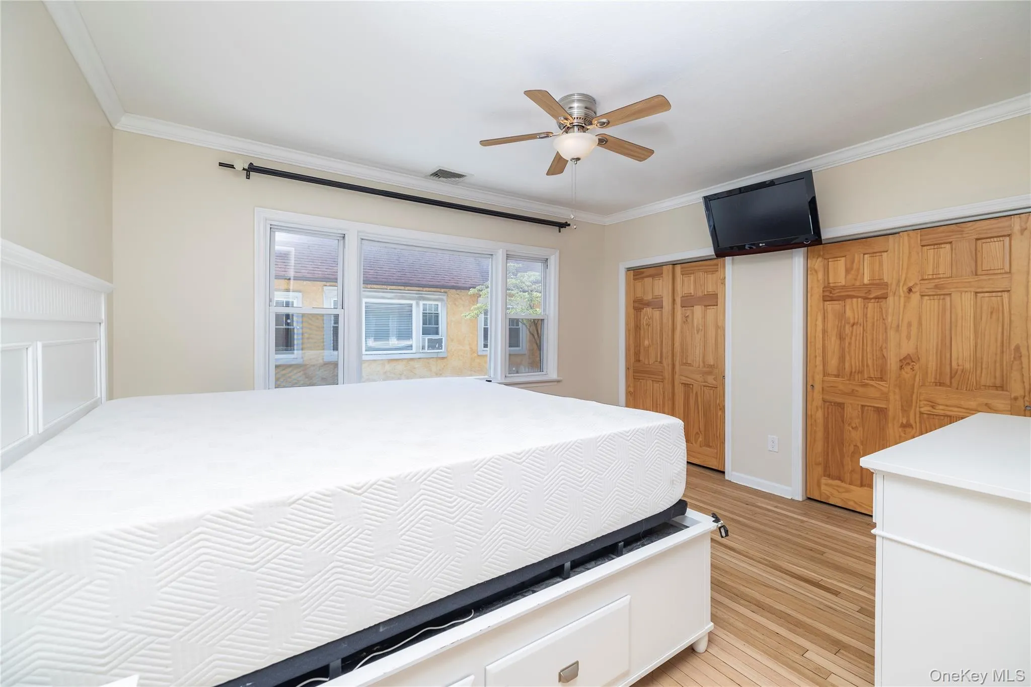 PRIMARY SUITE with light wood finished floors, ornamental molding, and a ceiling fan PRIMARY SUITE with light wood finished floors, ornamental molding, and a ceiling fan