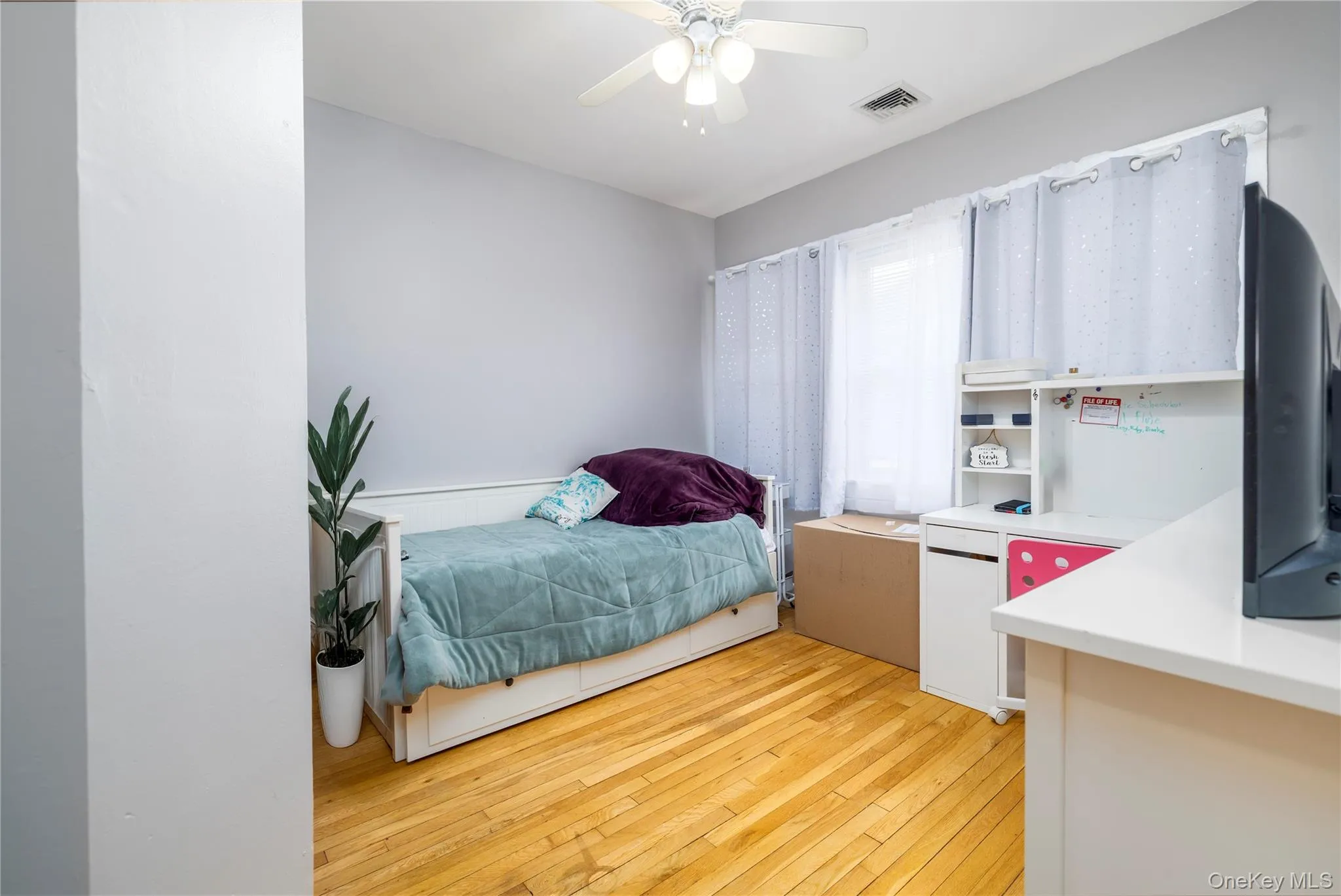 Bedroom with light wood-style flooring and ceiling fan Bedroom with light wood-style flooring and ceiling fan