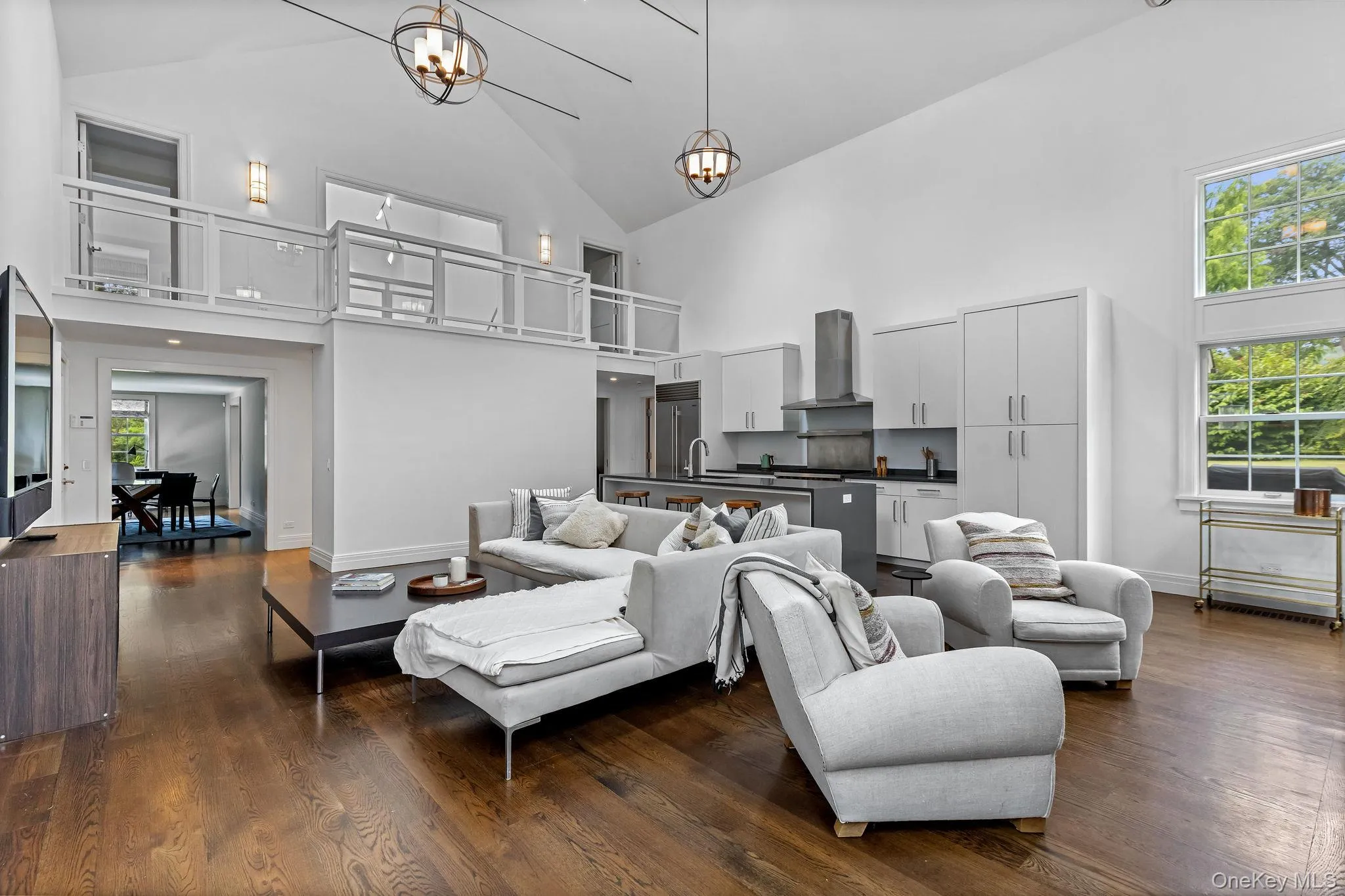 Great room featuring open kitchen, vaulted ceiling, wood flooring, lofted space, and wood burning fireplace Great room featuring open kitchen, vaulted ceiling, wood flooring, lofted space, and wood burning fireplace