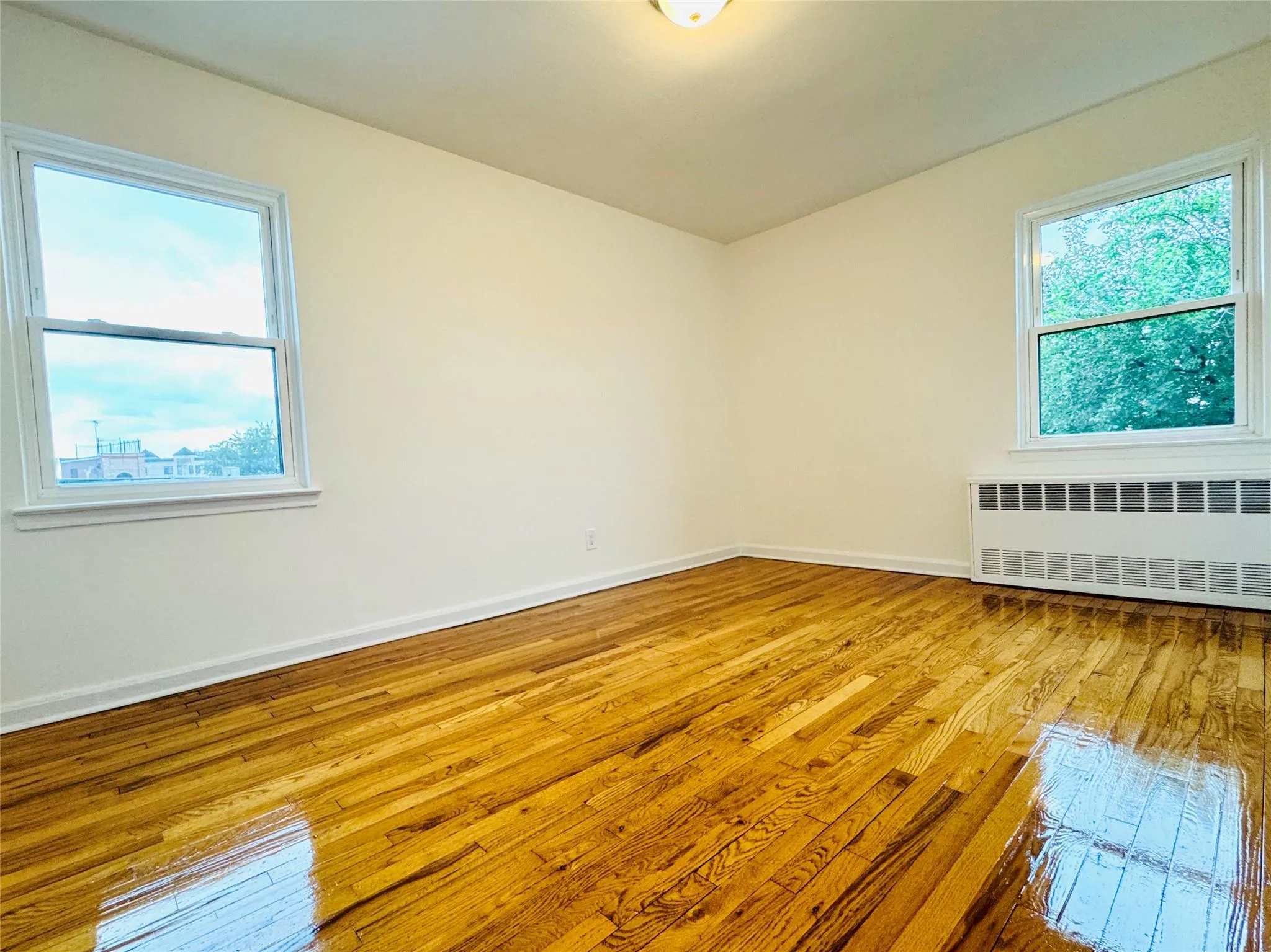 Empty room with wood-type flooring and radiator Empty room with wood-type flooring and radiator