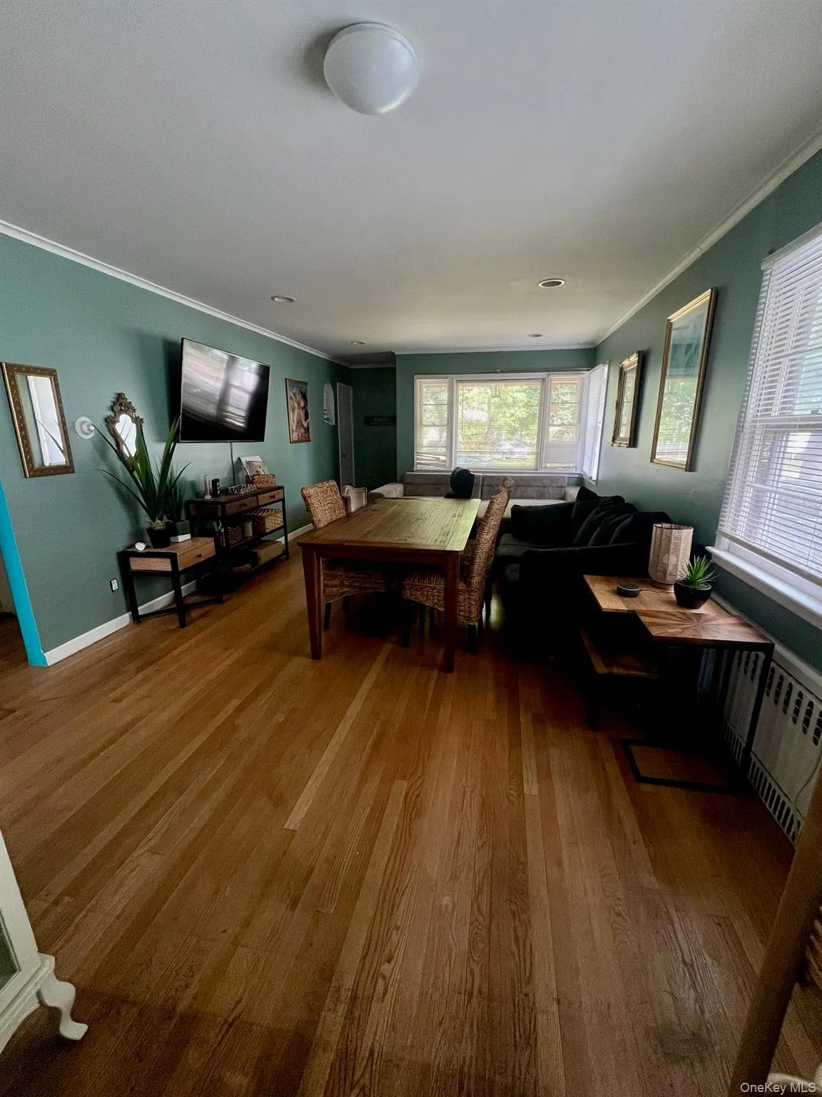 Living area featuring ornamental molding and wood finished floors Living area featuring ornamental molding and wood finished floors