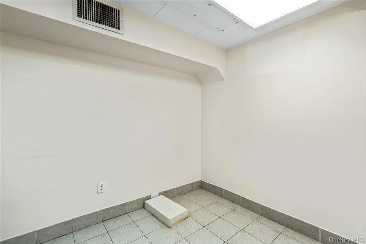 Empty room with baseboards and light tile patterned floors Empty room with baseboards and light tile patterned floors