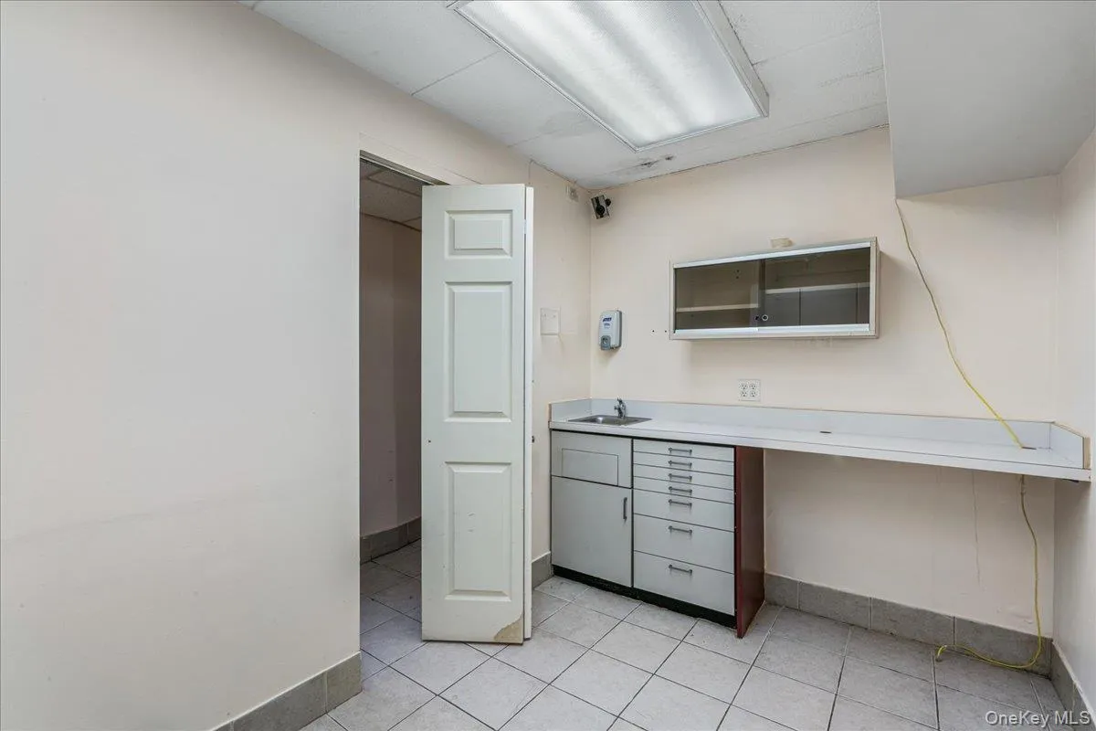 Unfurnished office with baseboards and light tile patterned floors Unfurnished office with baseboards and light tile patterned floors