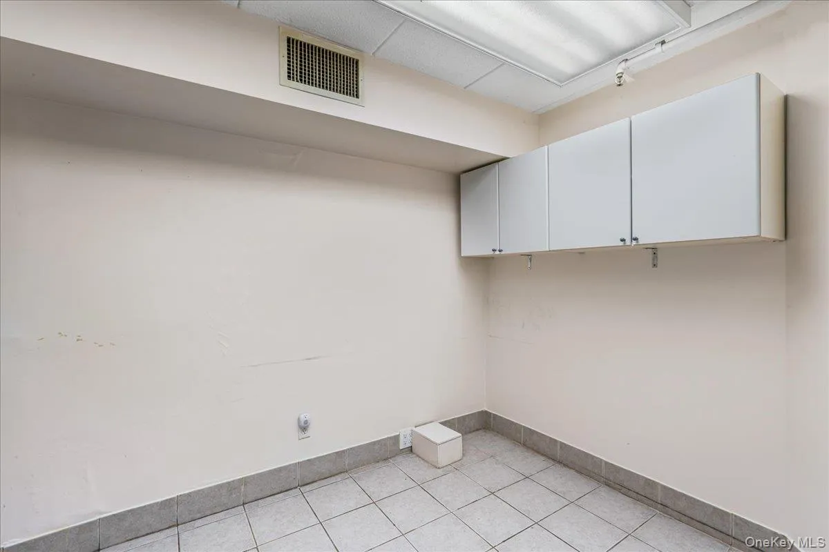 Washroom with light tile patterned floors and baseboards Washroom with light tile patterned floors and baseboards