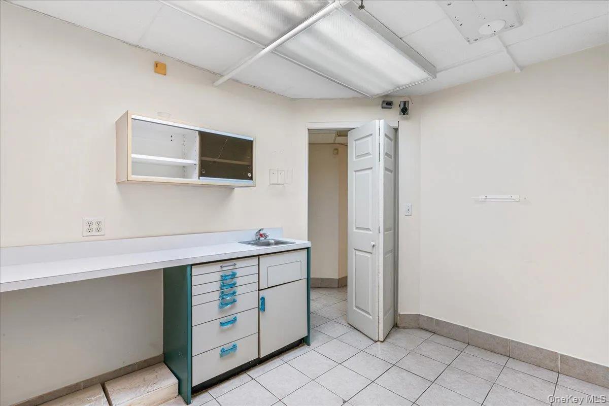 Unfurnished office with baseboards and light tile patterned floors Unfurnished office with baseboards and light tile patterned floors