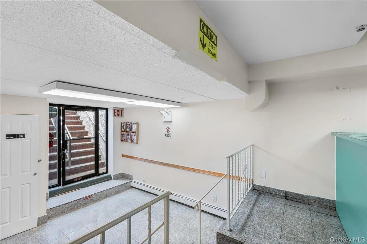 Staircase featuring a baseboard radiator and baseboards Staircase featuring a baseboard radiator and baseboards