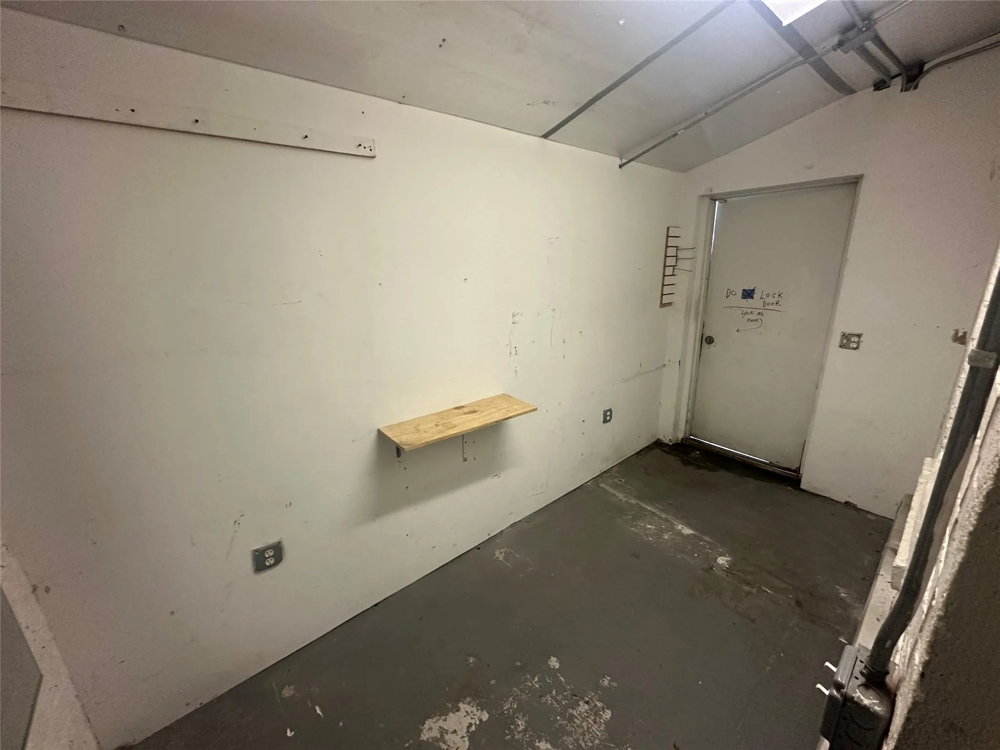 Spare room featuring concrete flooring and vaulted ceiling Spare room featuring concrete flooring and vaulted ceiling