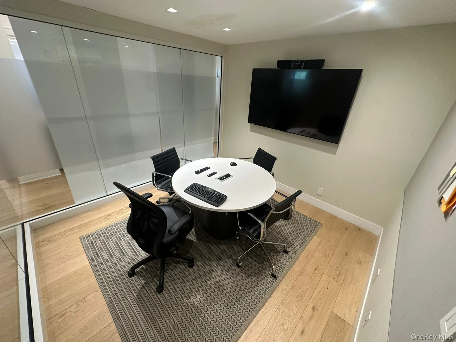Office space with light wood-style floors and recessed lighting Office space with light wood-style floors and recessed lighting