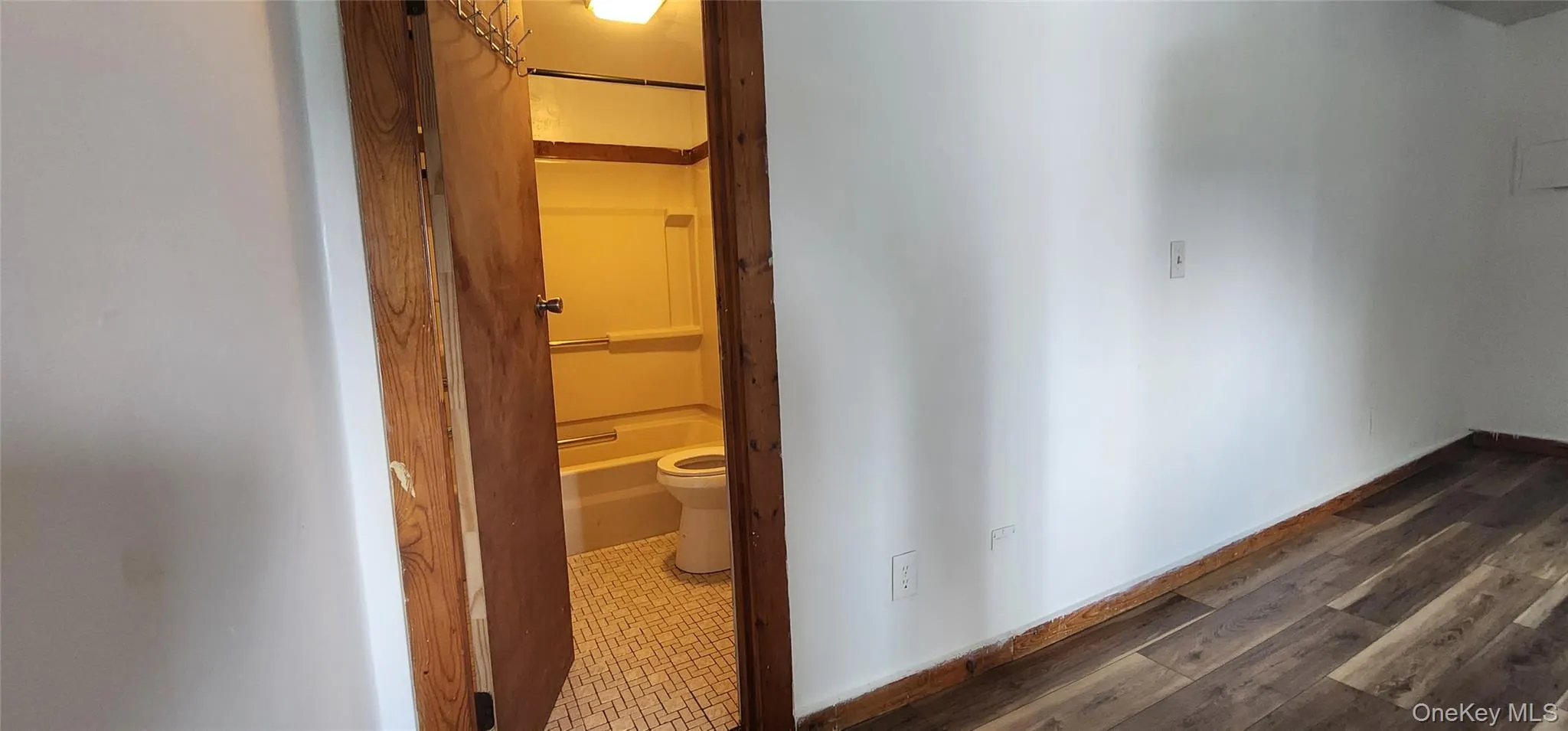 Hallway with baseboards and dark wood finished floors Hallway with baseboards and dark wood finished floors
