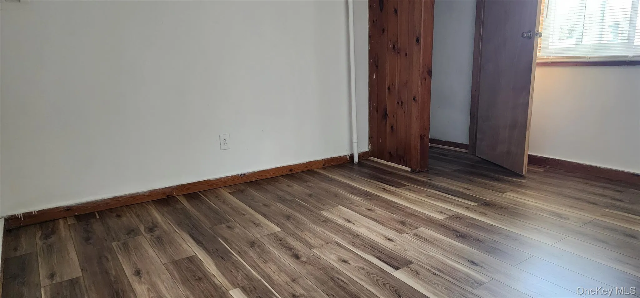 Unfurnished bedroom with wood finished floors and a closet Unfurnished bedroom with wood finished floors and a closet