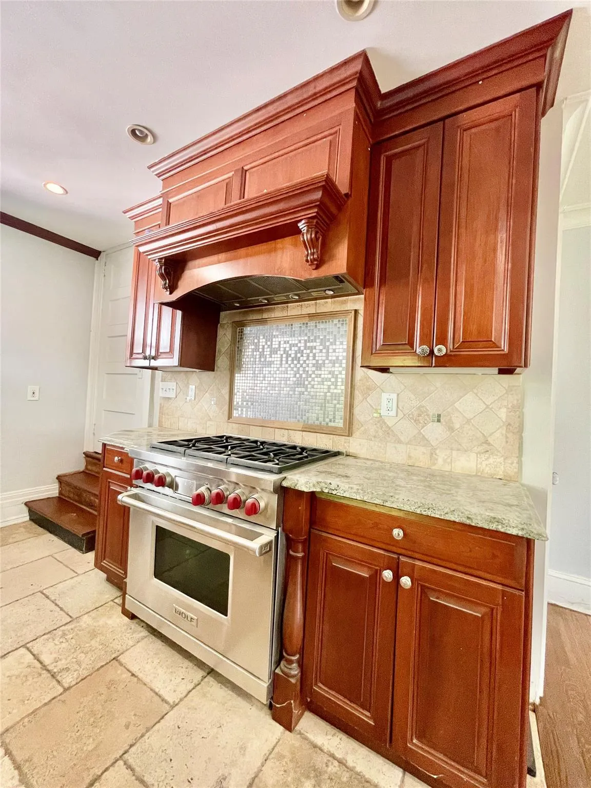 Kitchen featuring luxury stove, recessed lighting, custom exhaust hood, decorative backsplash, and ornamental molding Kitchen featuring luxury stove, recessed lighting, custom exhaust hood, decorative backsplash, and ornamental molding
