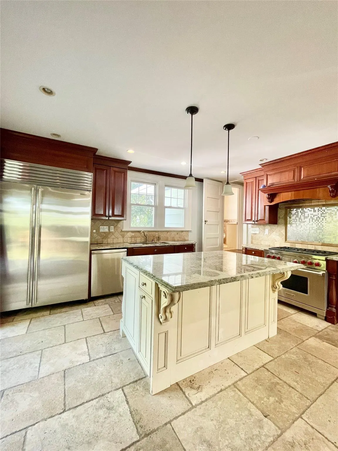 Kitchen with tasteful backsplash, high quality appliances, light stone countertops, a center island, and recessed lighting Kitchen with tasteful backsplash, high quality appliances, light stone countertops, a center island, and recessed lighting