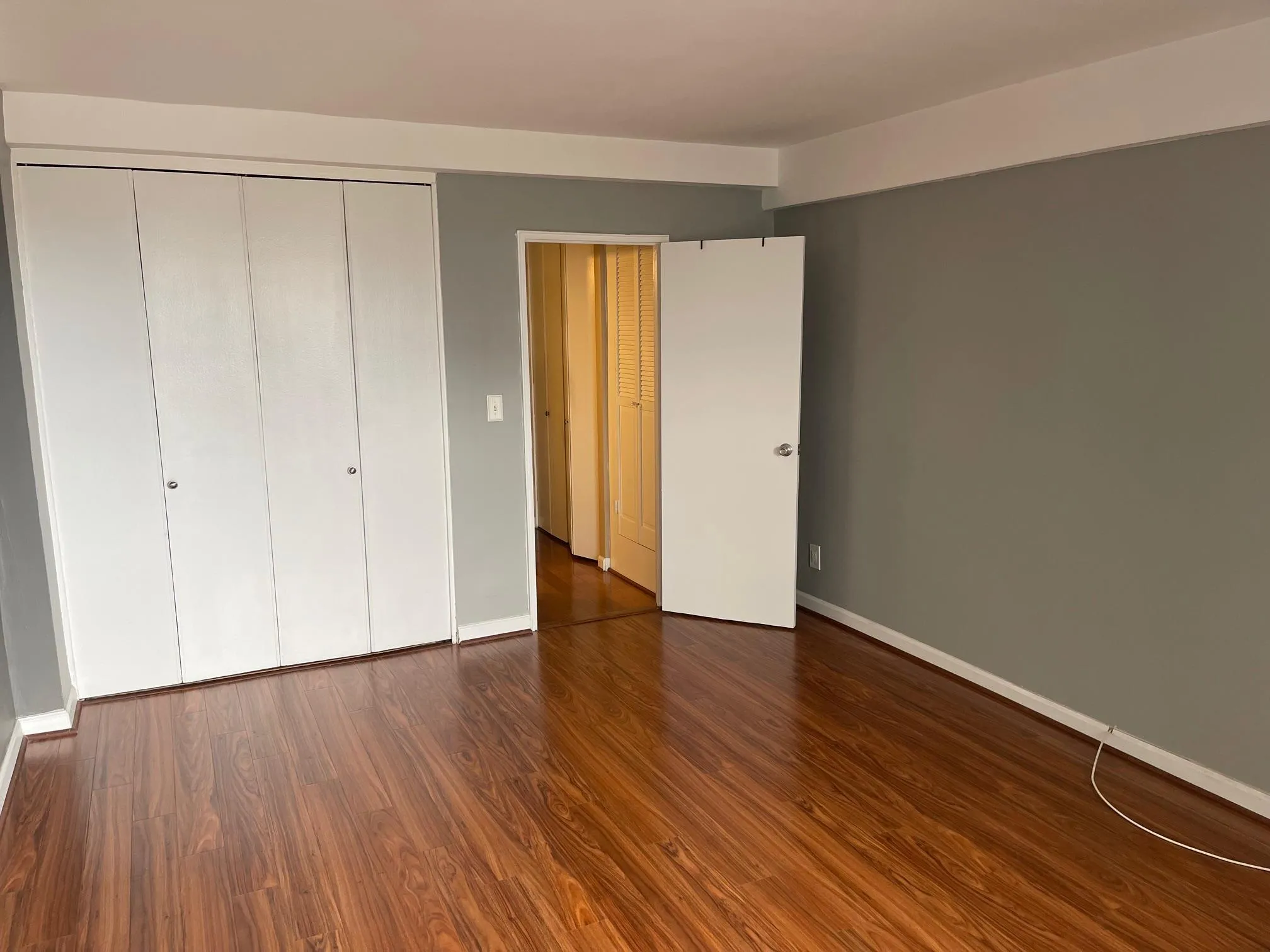Unfurnished bedroom with dark wood-style flooring and a closet Unfurnished bedroom with dark wood-style flooring and a closet
