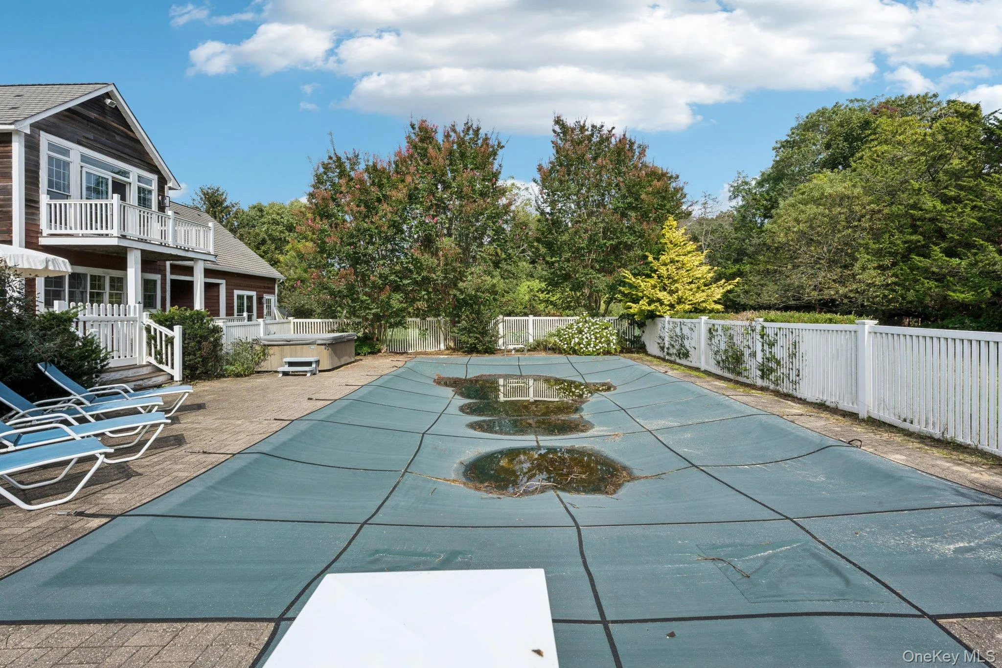 A picturesque view showcasing the swimming pool, sunlit patio, and hot tub, all set within a private fenced backyard and complemented by a balcony overlooking the serene outdoor oasis. A picturesque view showcasing the swimming pool, sunlit patio, and hot tub, all set within a private fenced backyard and complemented by a balcony overlooking the serene outdoor oasis.