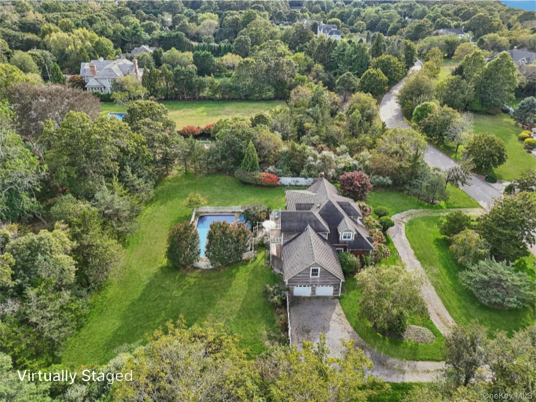 Aerial side perspective showcasing the property’s two-car attached garage and surrounding landscape. Virtually Staged to show opened pool. Aerial side perspective showcasing the property’s two-car attached garage and surrounding landscape. Virtually Staged to show opened pool.