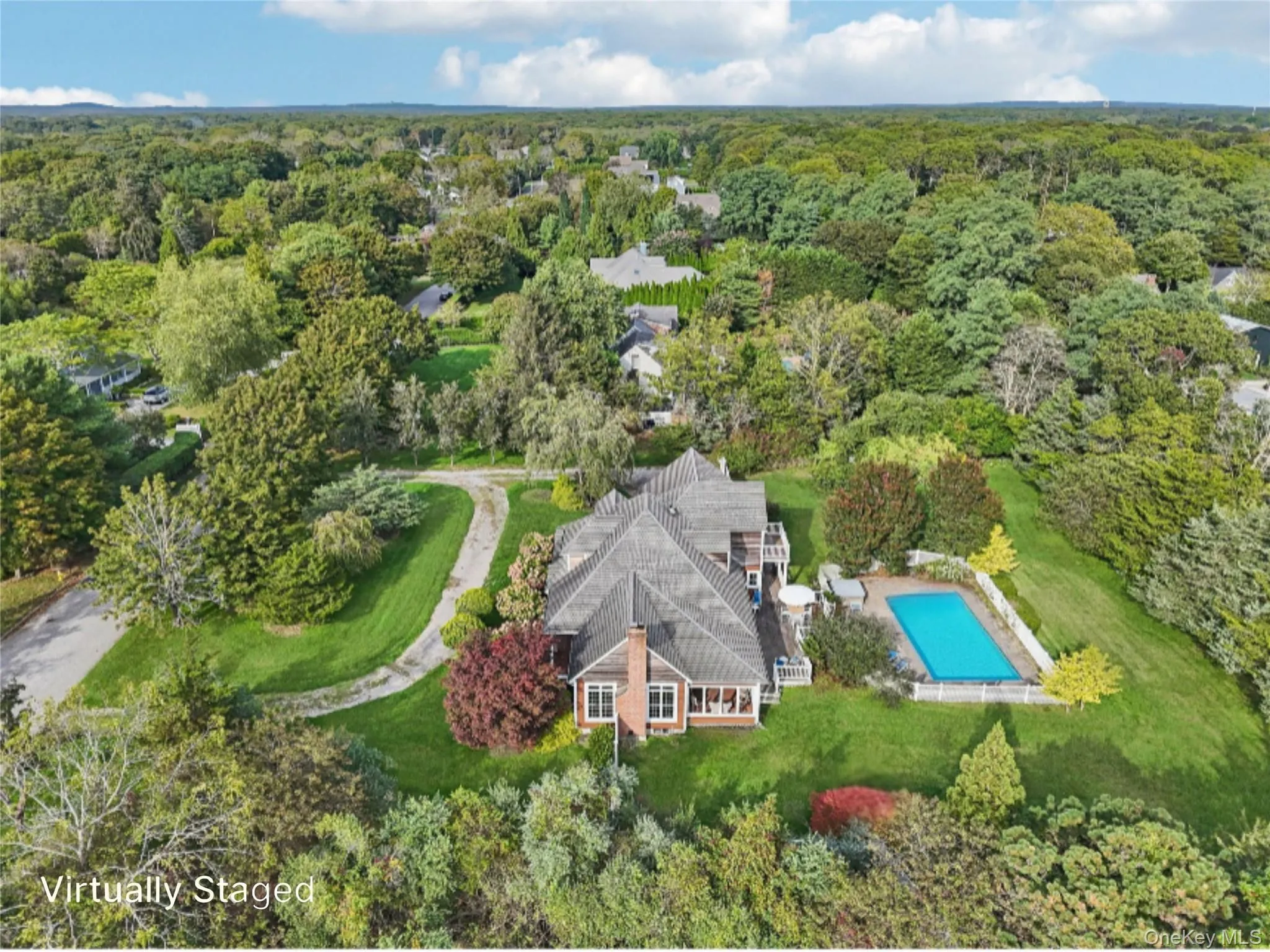 An aerial side perspective reveals the property’s architectural elegance, featuring a sunroom framed by floor-to-ceiling windows, and lushly landscaped grounds. Virtually Staged to Show open pool. An aerial side perspective reveals the property’s architectural elegance, featuring a sunroom framed by floor-to-ceiling windows, and lushly landscaped grounds. Virtually Staged to Show open pool.