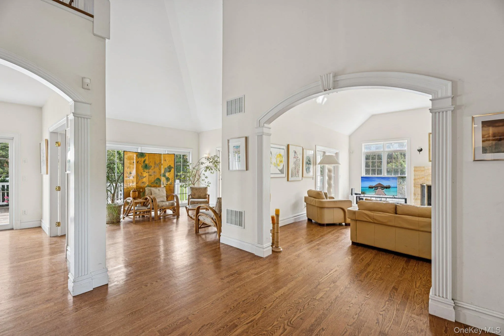 An impressive foyer adorned with oak flooring, vaulted cathedral ceilings, and arched walkways that lead to a sweeping grand stairway. An impressive foyer adorned with oak flooring, vaulted cathedral ceilings, and arched walkways that lead to a sweeping grand stairway.