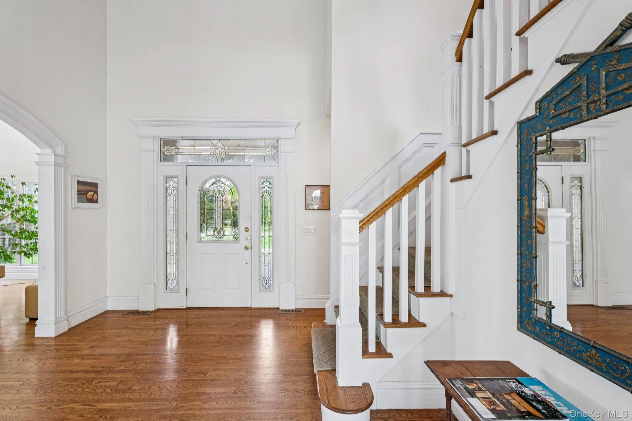 Elegant foyer featuring oak floors, soaring cathedral ceilings, timeless arched walkways, and a beautifully designed stairway. Elegant foyer featuring oak floors, soaring cathedral ceilings, timeless arched walkways, and a beautifully designed stairway.
