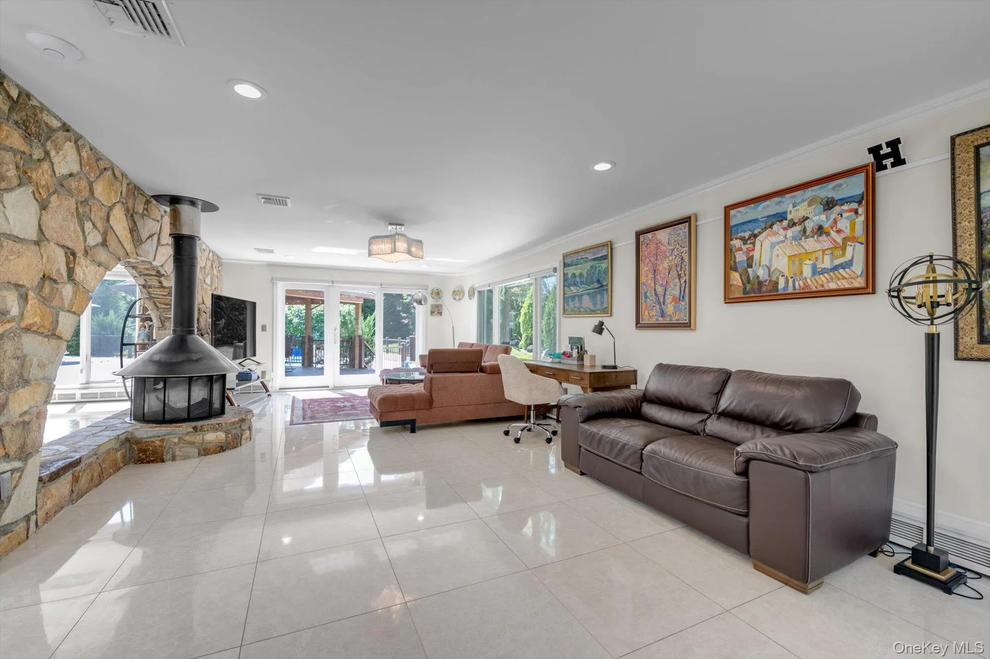 Family room with a wood Burning Fireplace, light tile patterned flooring, recessed lighting, ornamental molding, and a doors to Deck Family room with a wood Burning Fireplace, light tile patterned flooring, recessed lighting, ornamental molding, and a doors to Deck