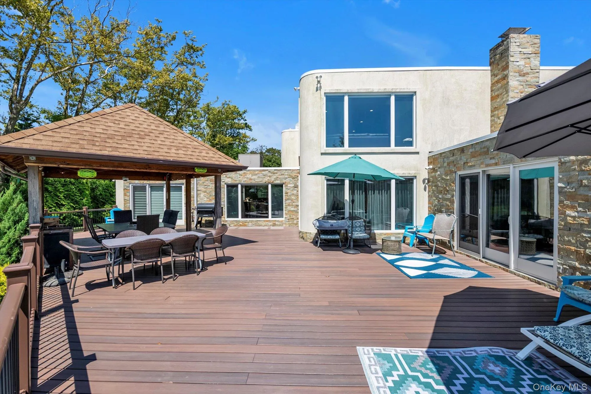 Trex terrace with a gazebo, outdoor dining space, and area for grilling Trex terrace with a gazebo, outdoor dining space, and area for grilling