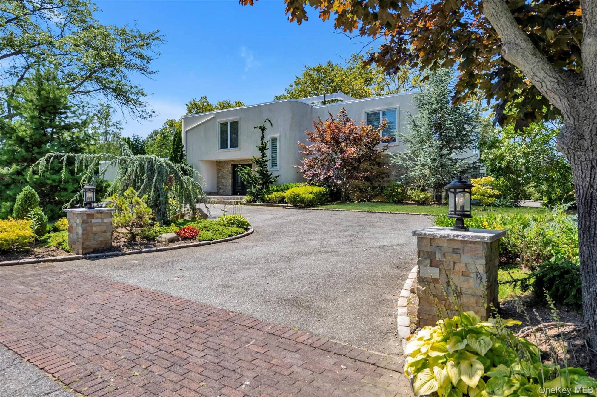 View of front of house featuring stucco siding and circular driveway View of front of house featuring stucco siding and circular driveway