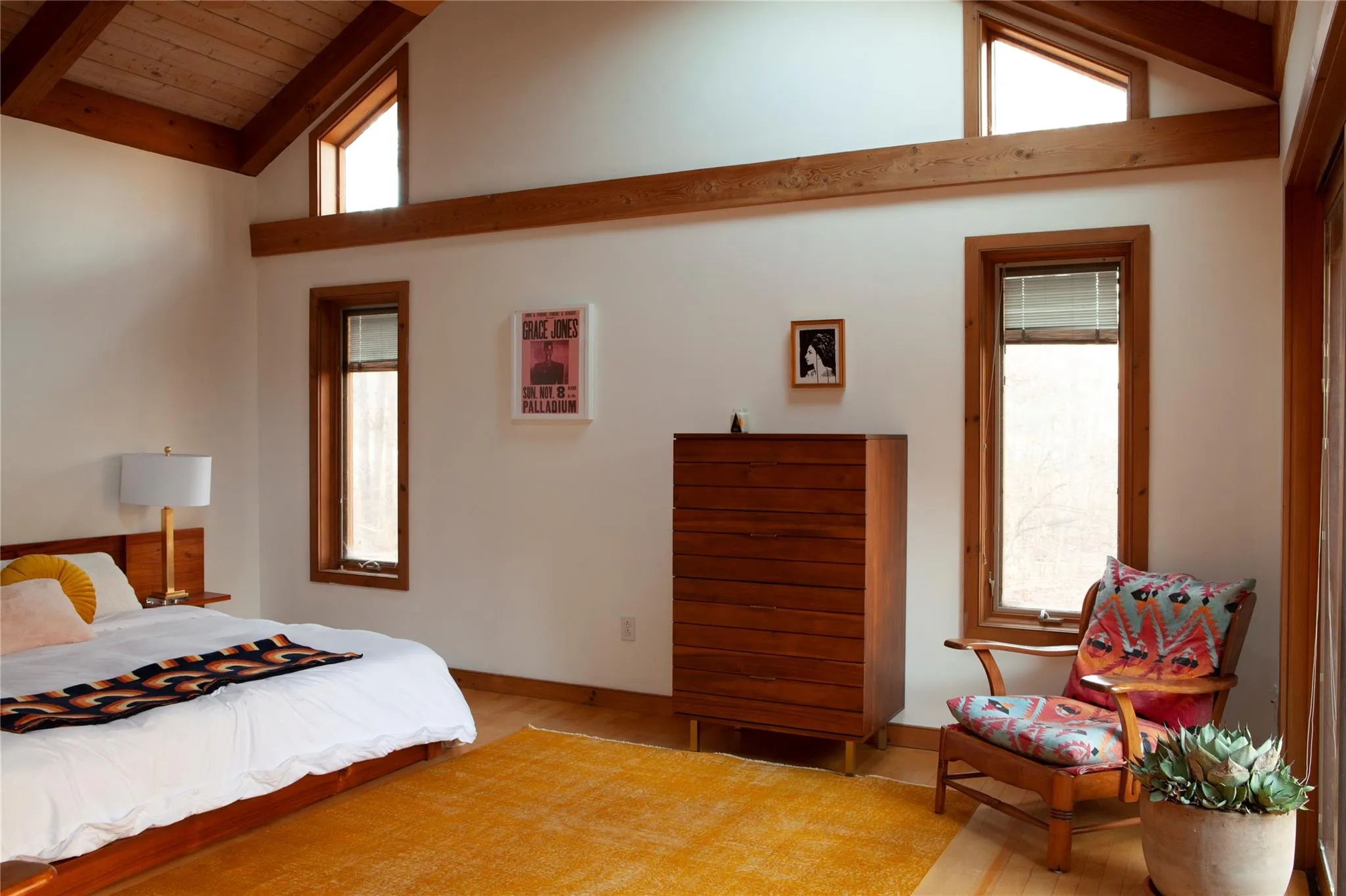 Bedroom with light wood-type flooring, a wood ceiling with exposed beams, and high vaulted ceiling Bedroom with light wood-type flooring, a wood ceiling with exposed beams, and high vaulted ceiling