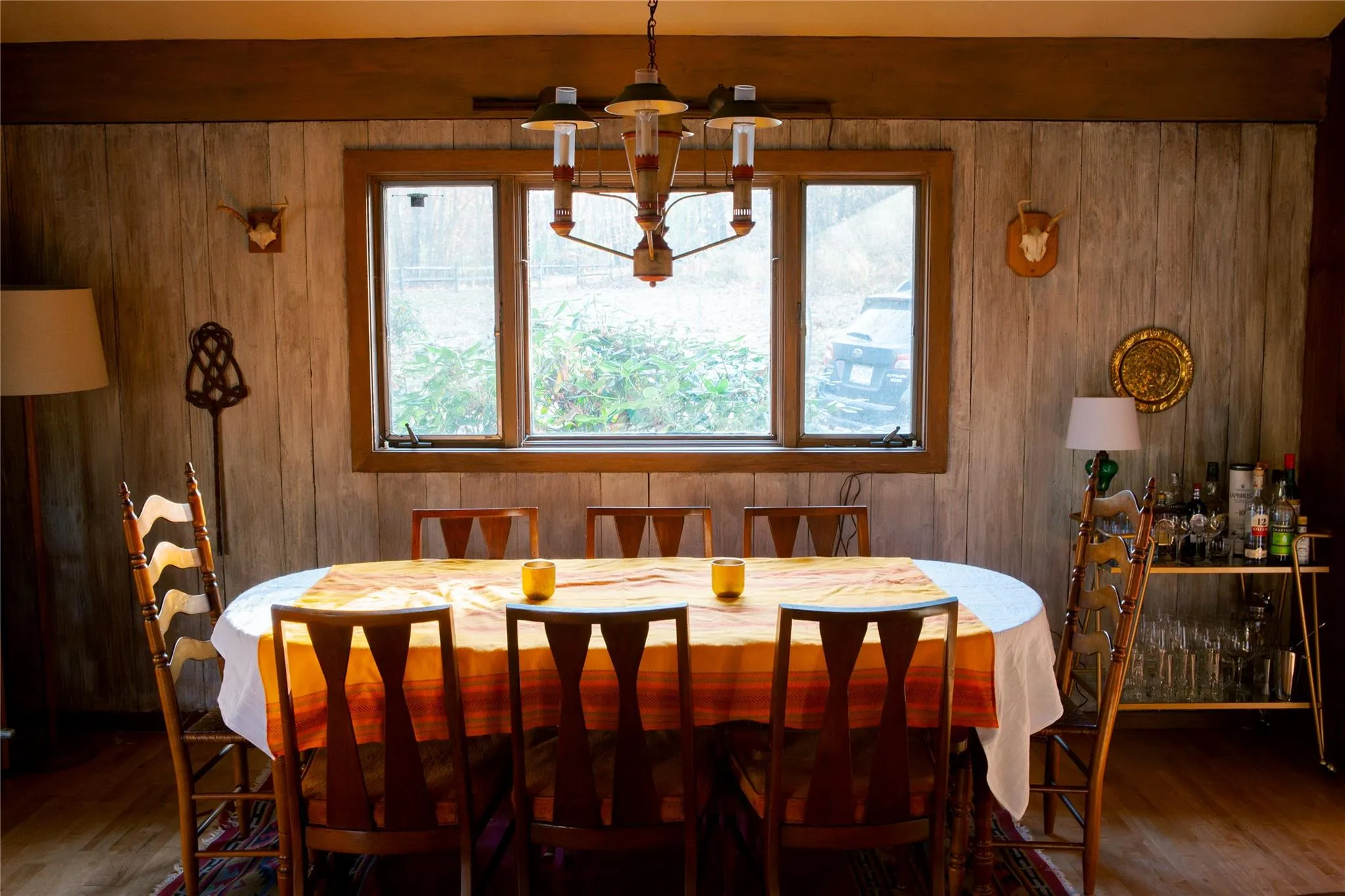 Dining area featuring wood finished floors, a chandelier, and wooden walls Dining area featuring wood finished floors, a chandelier, and wooden walls