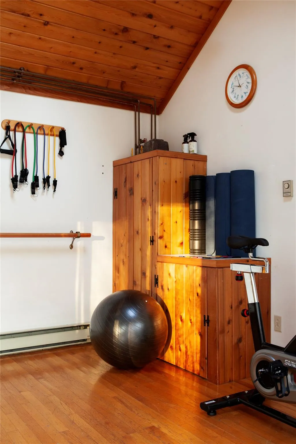 Exercise area featuring wooden ceiling, lofted ceiling, baseboard heating, and hardwood / wood-style flooring Exercise area featuring wooden ceiling, lofted ceiling, baseboard heating, and hardwood / wood-style flooring
