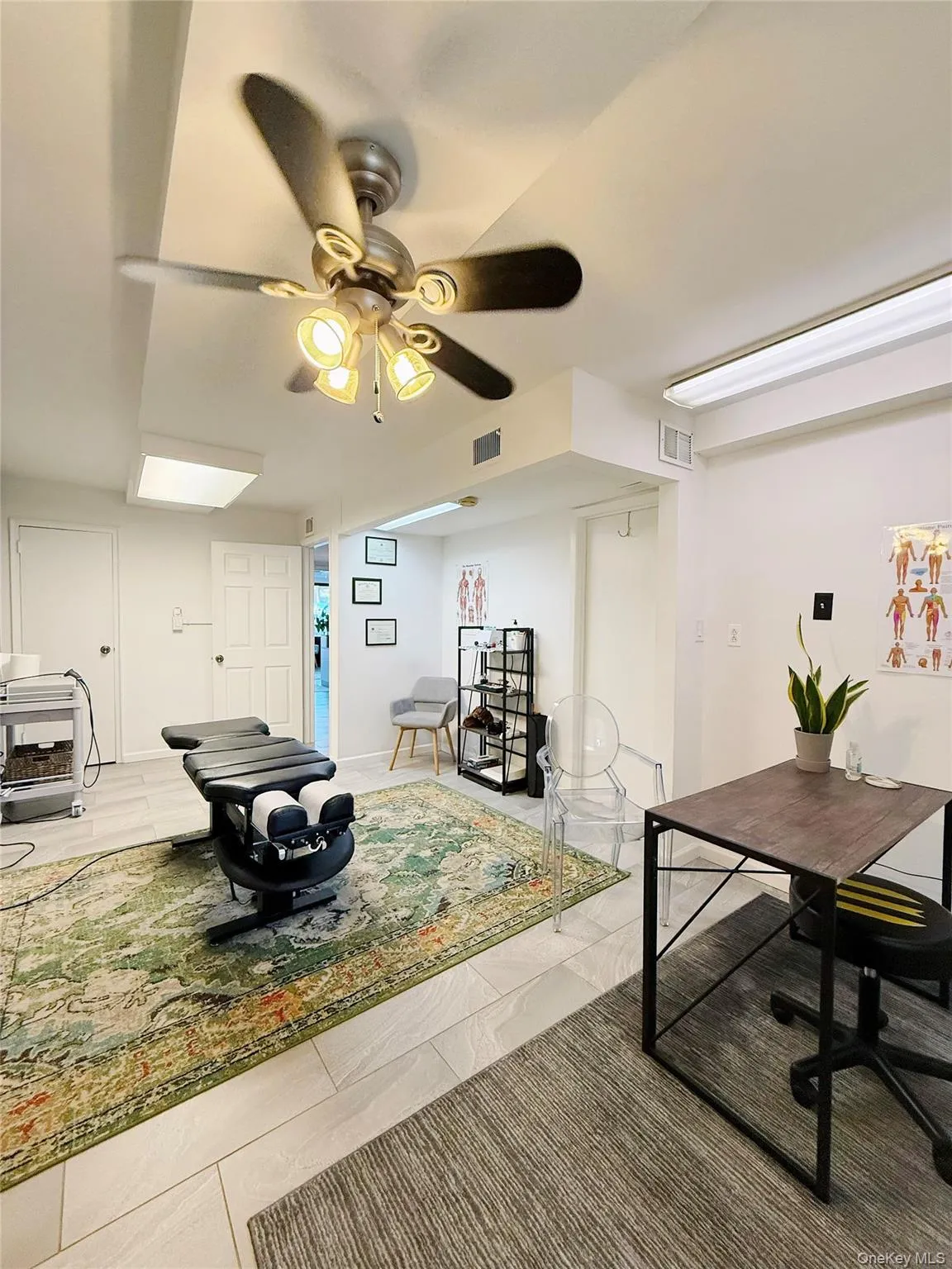 Recreation room featuring ceiling fan and tile patterned flooring Recreation room featuring ceiling fan and tile patterned flooring