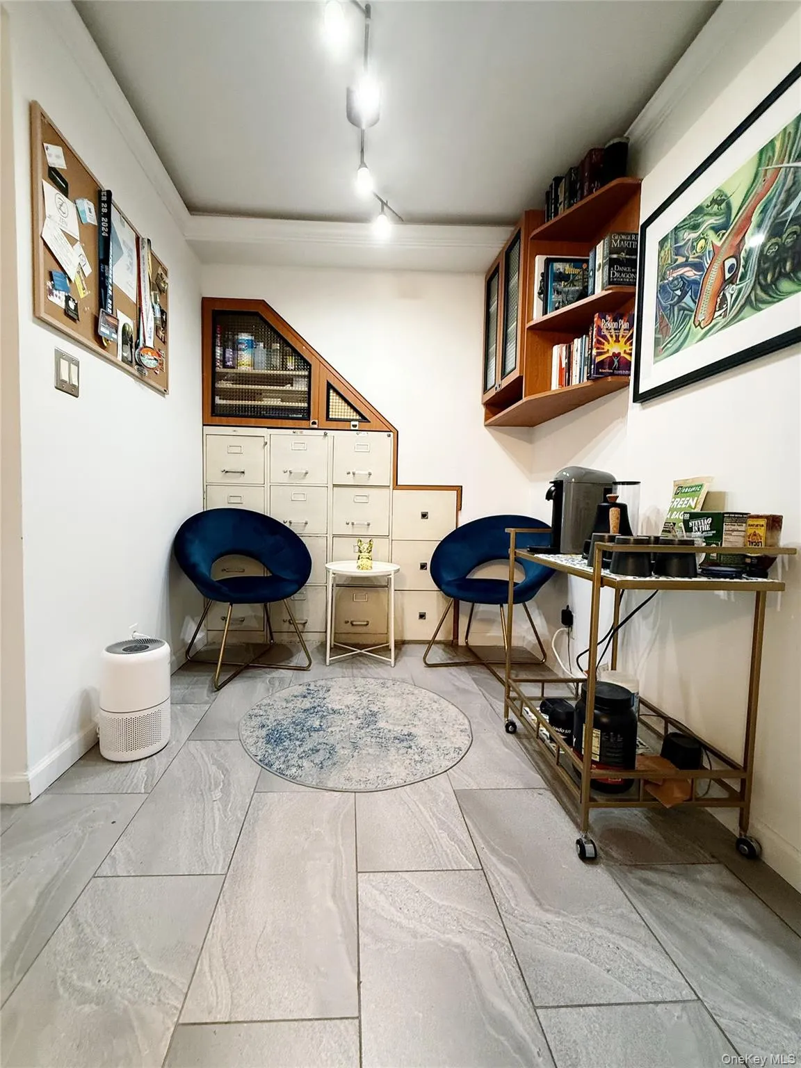 Living area featuring ornamental molding, rail lighting, and marble finish flooring Living area featuring ornamental molding, rail lighting, and marble finish flooring