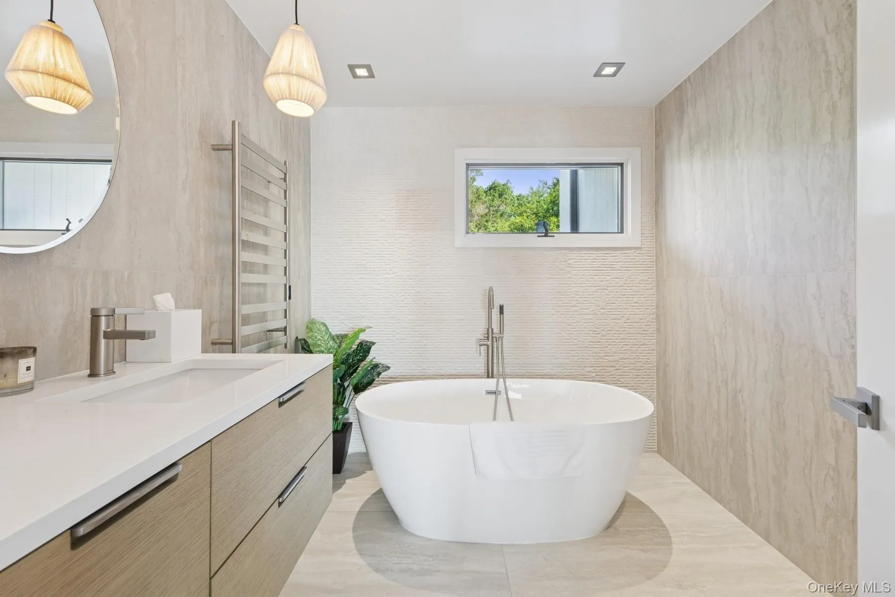 Bathroom with a freestanding bath, vanity, and tile walls Bathroom with a freestanding bath, vanity, and tile walls