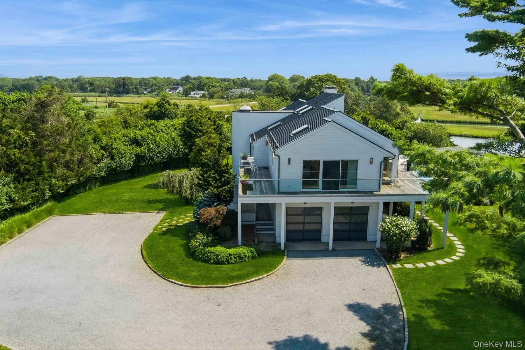 View of front of home with a balcony, driveway, a front yard, a chimney, and an attached garage View of front of home with a balcony, driveway, a front yard, a chimney, and an attached garage