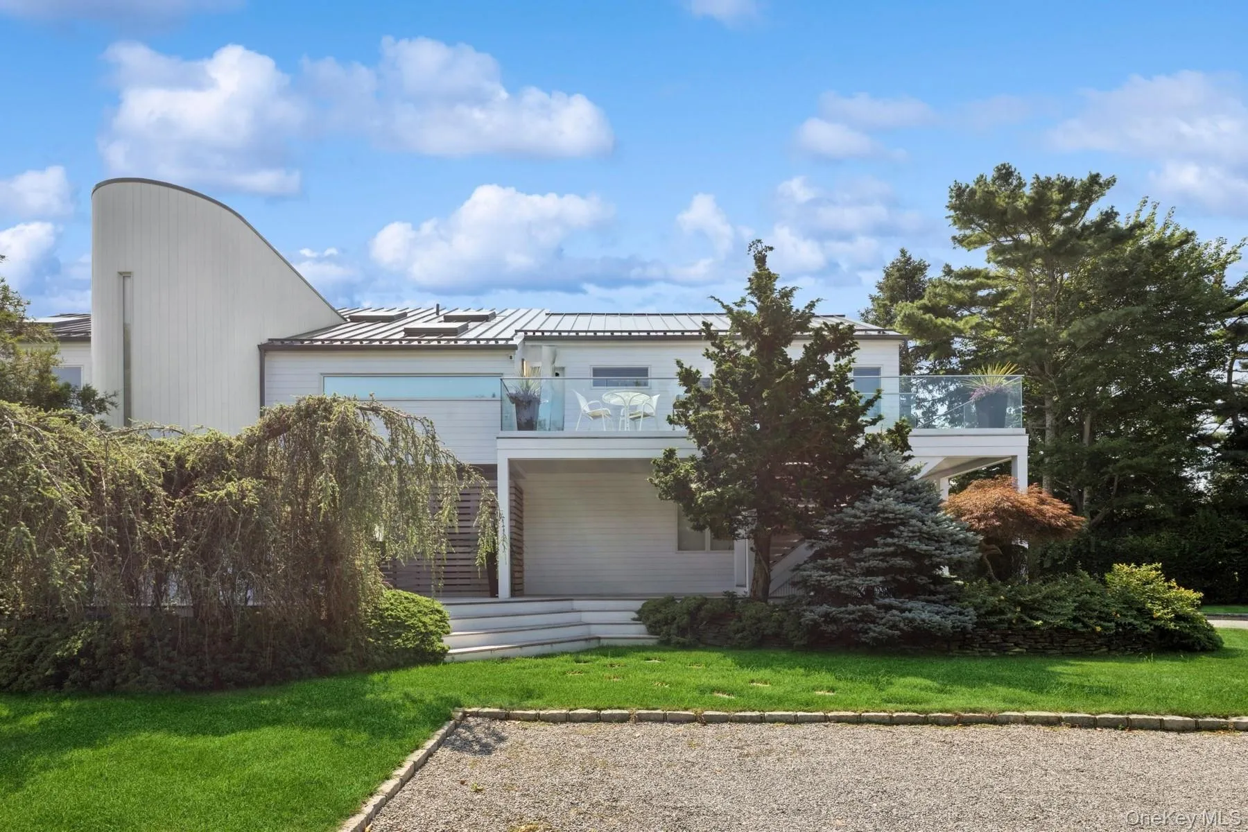 Back of property with a lawn, a metal roof, and a standing seam roof Back of property with a lawn, a metal roof, and a standing seam roof