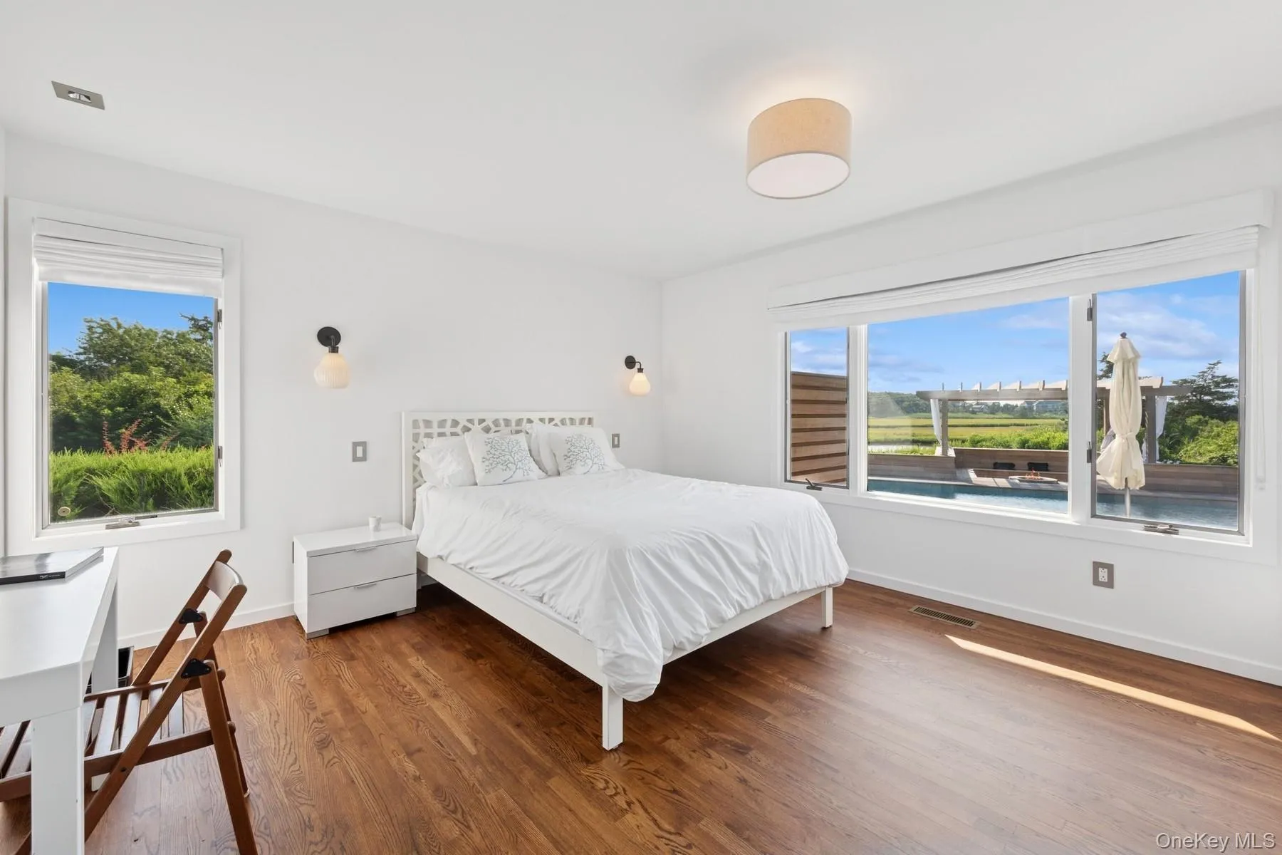 Bedroom with multiple windows and wood finished floors Bedroom with multiple windows and wood finished floors