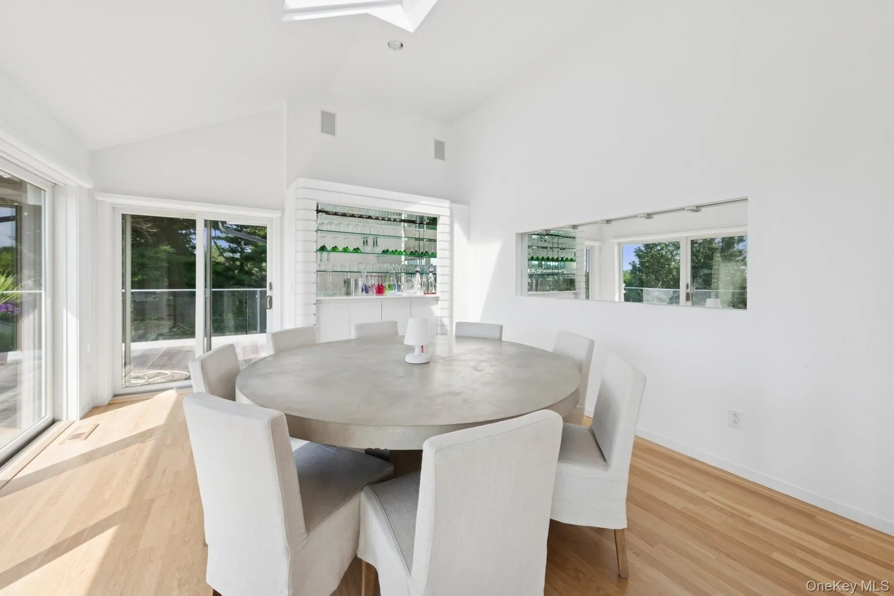 Dining area with plenty of natural light, wood finished floors, a skylight, and high vaulted ceiling Dining area with plenty of natural light, wood finished floors, a skylight, and high vaulted ceiling