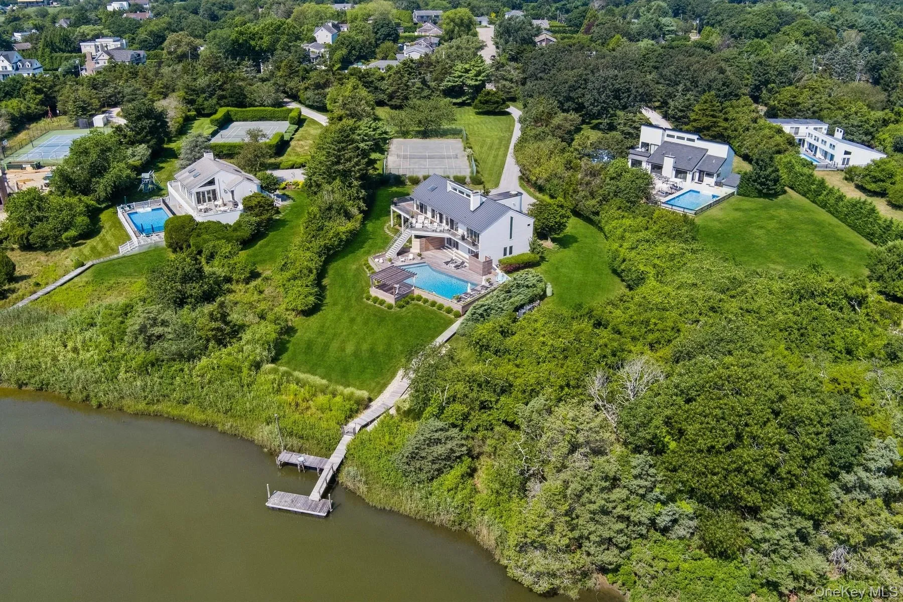 Bird\'s eye view of a pool area and a large body of water Bird\'s eye view of a pool area and a large body of water
