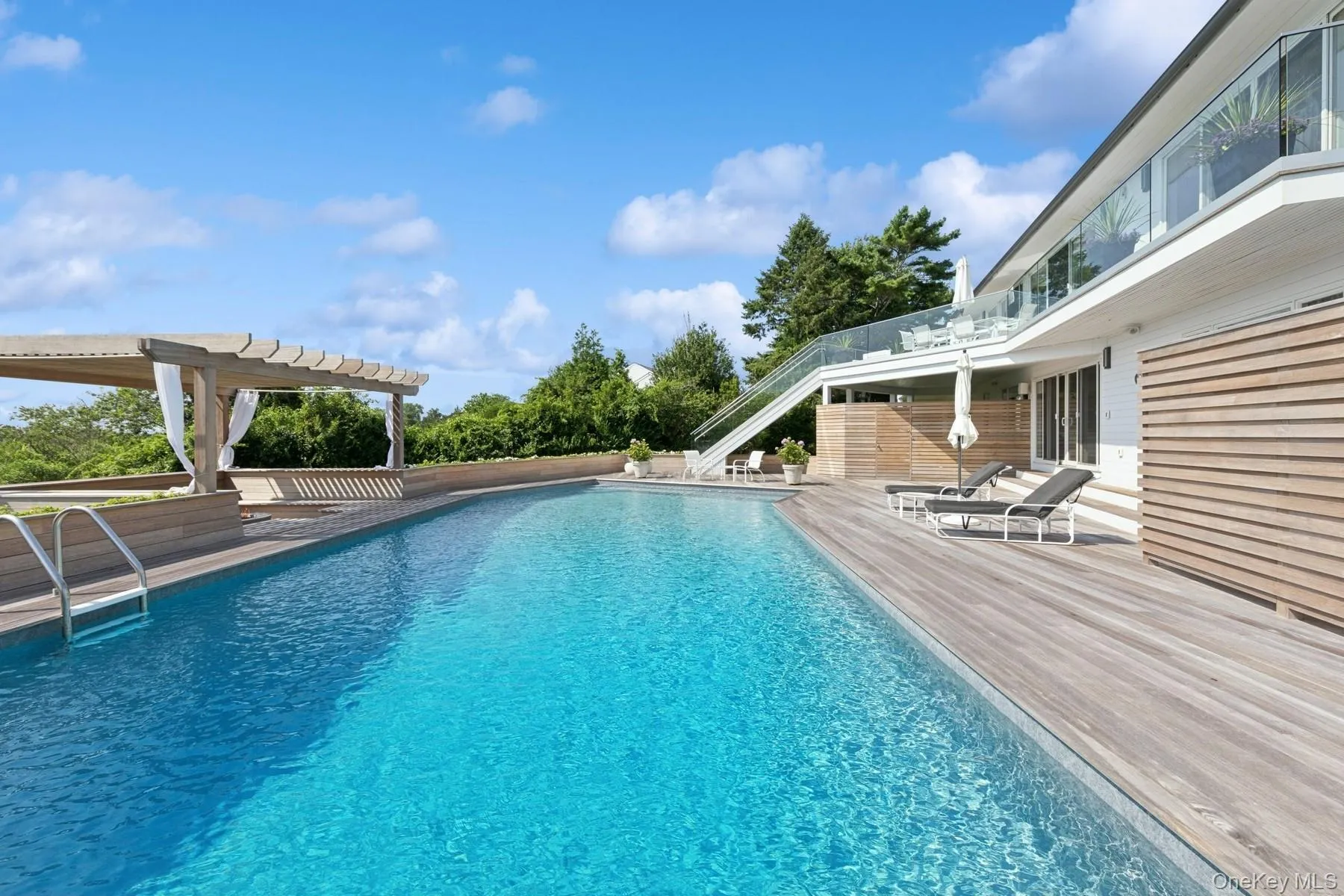 Outdoor pool featuring a pergola and a patio area Outdoor pool featuring a pergola and a patio area