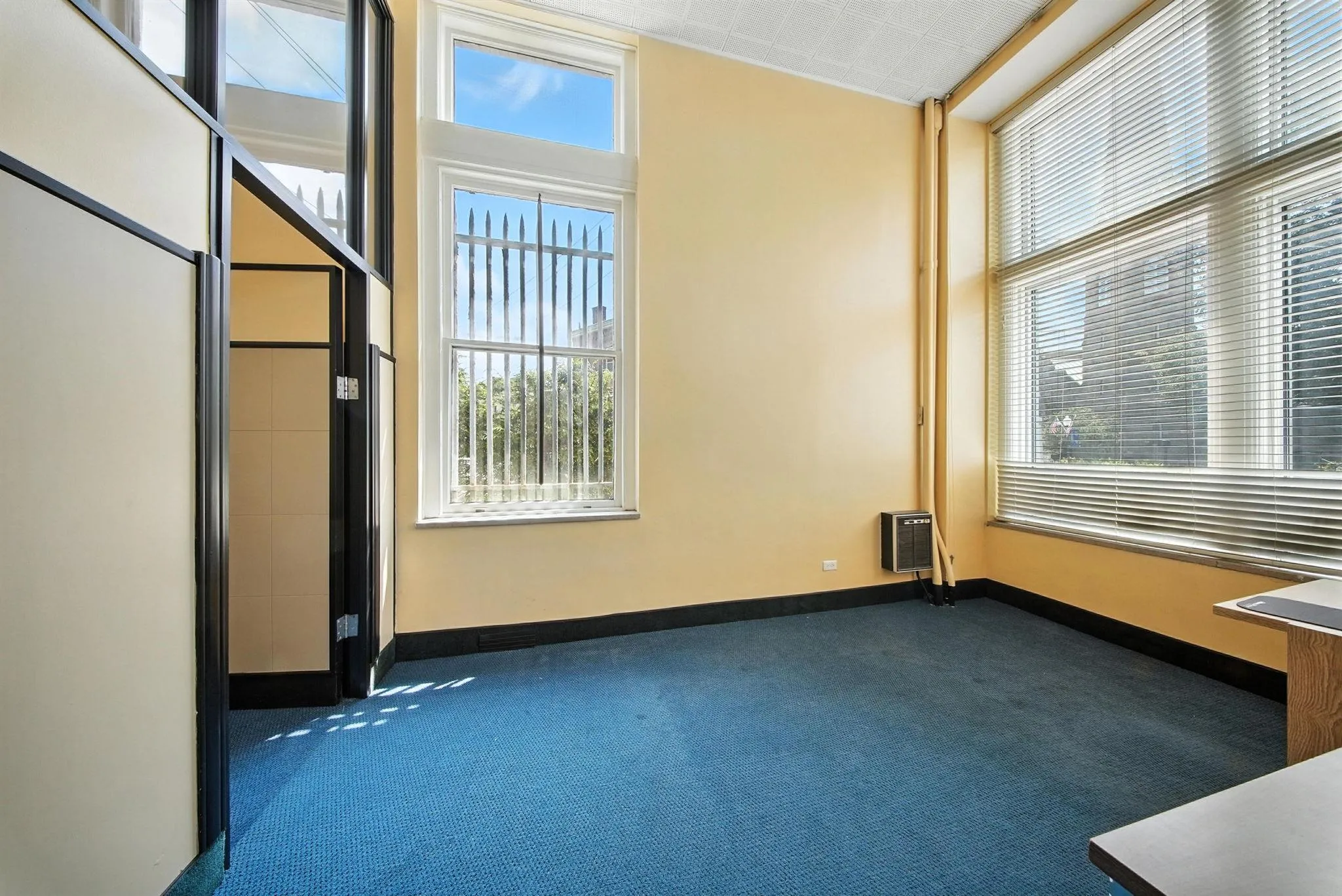 Empty room featuring dark colored carpet and heating unit Empty room featuring dark colored carpet and heating unit