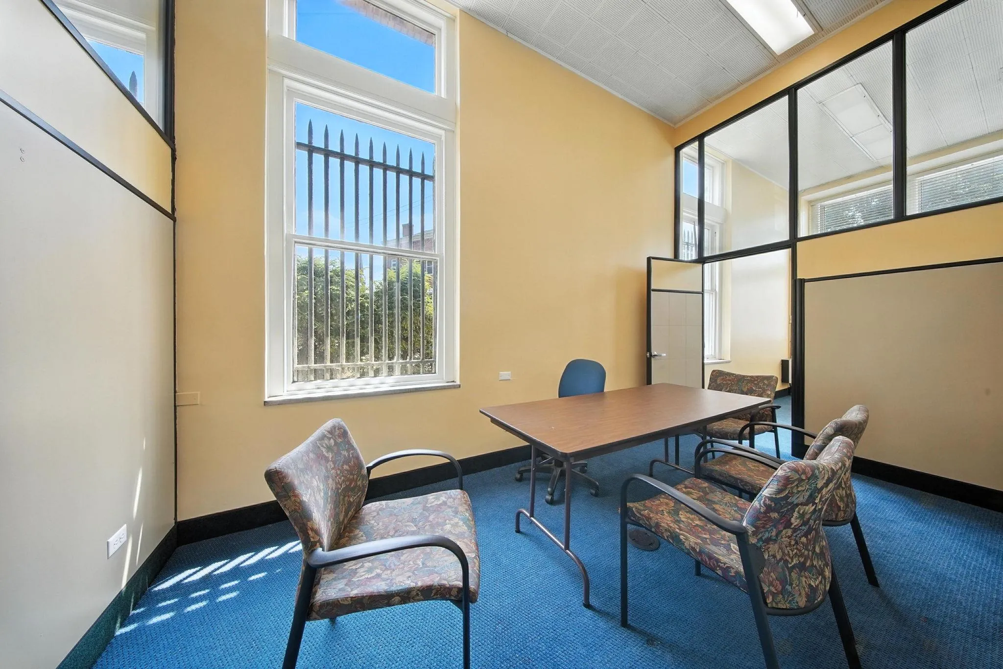 Office area featuring carpet flooring and a towering ceiling Office area featuring carpet flooring and a towering ceiling