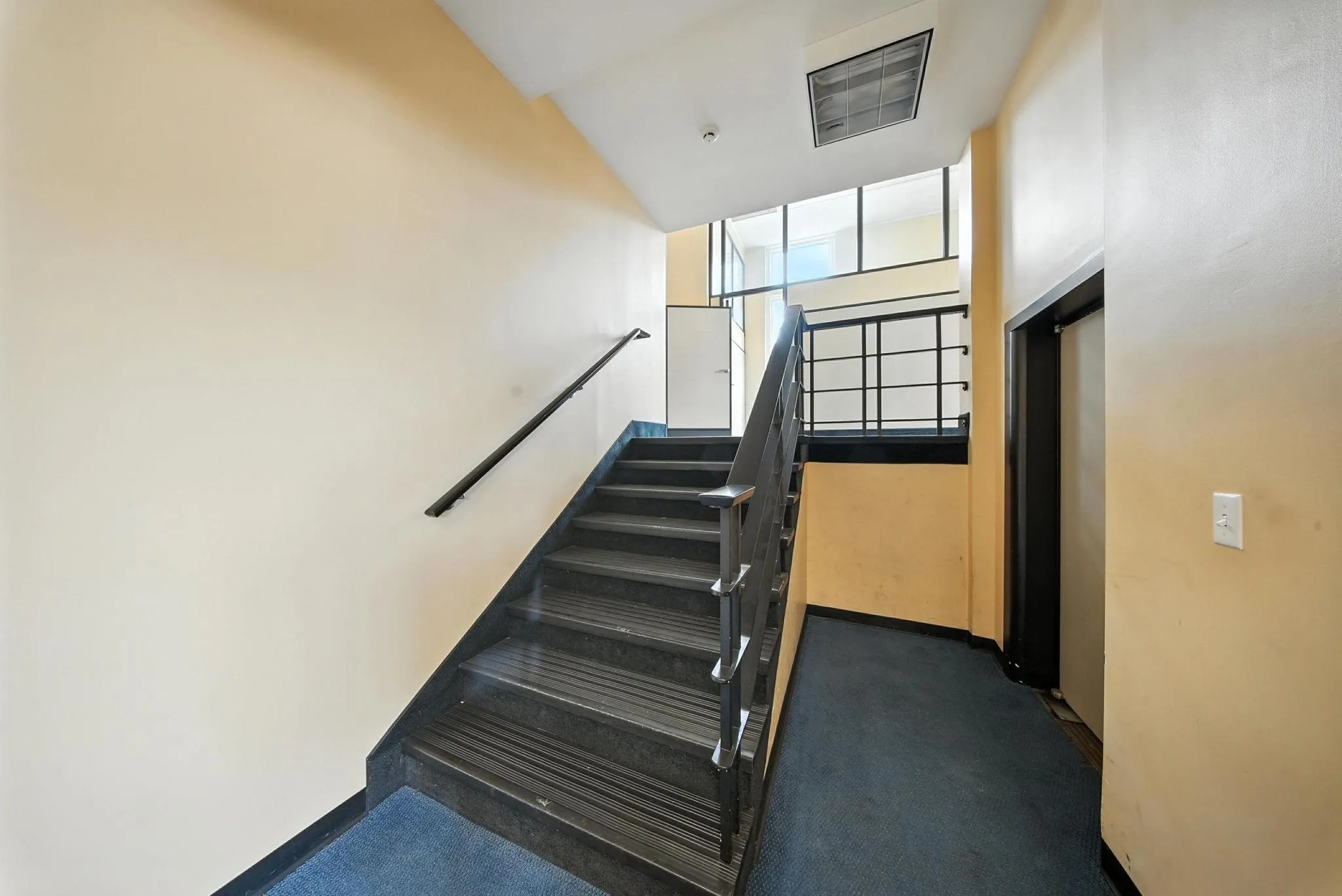 Stairs with carpet floors and a high ceiling Stairs with carpet floors and a high ceiling