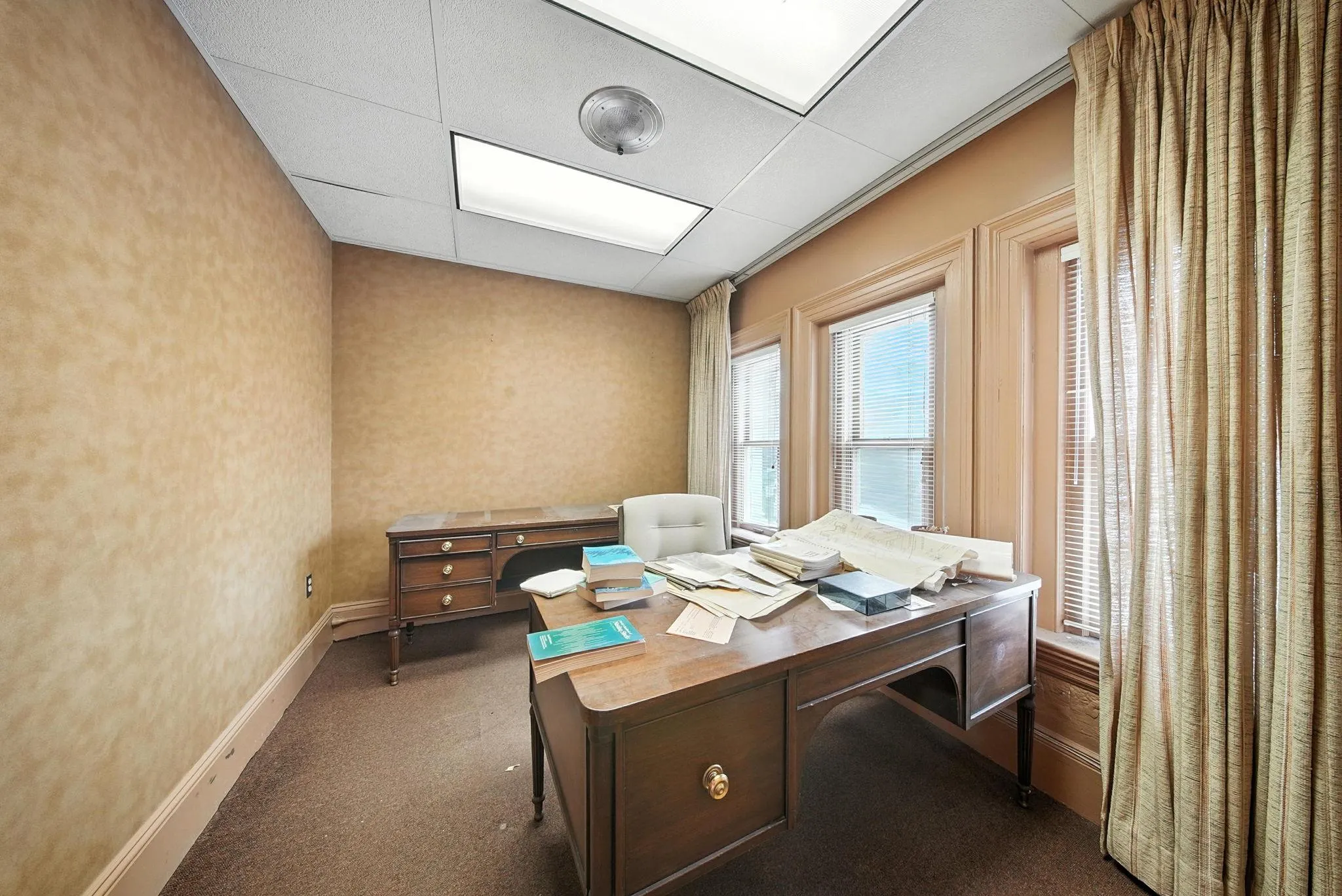 Office with dark colored carpet and a paneled ceiling Office with dark colored carpet and a paneled ceiling