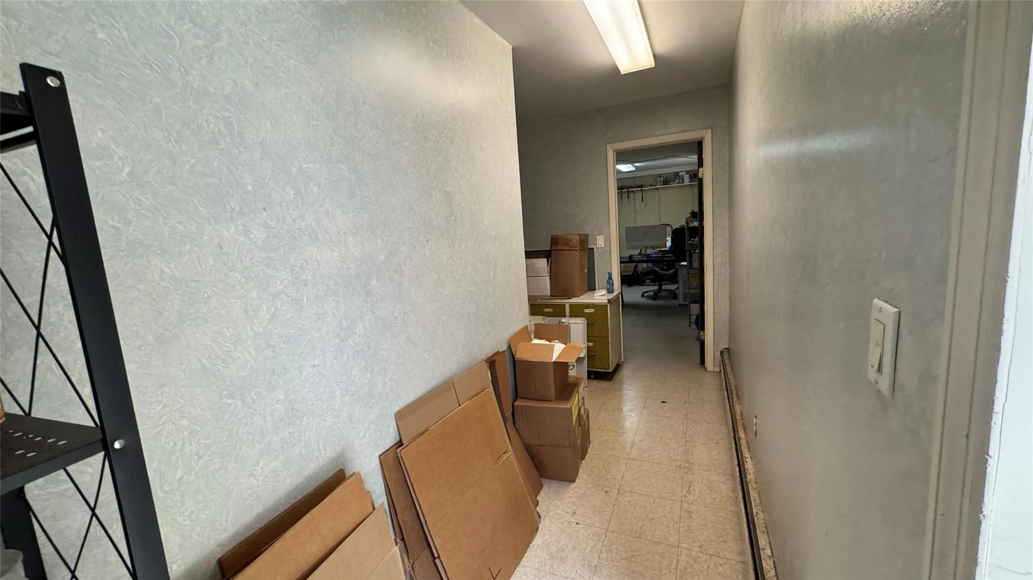 Hallway with light floors and a textured wall Hallway with light floors and a textured wall