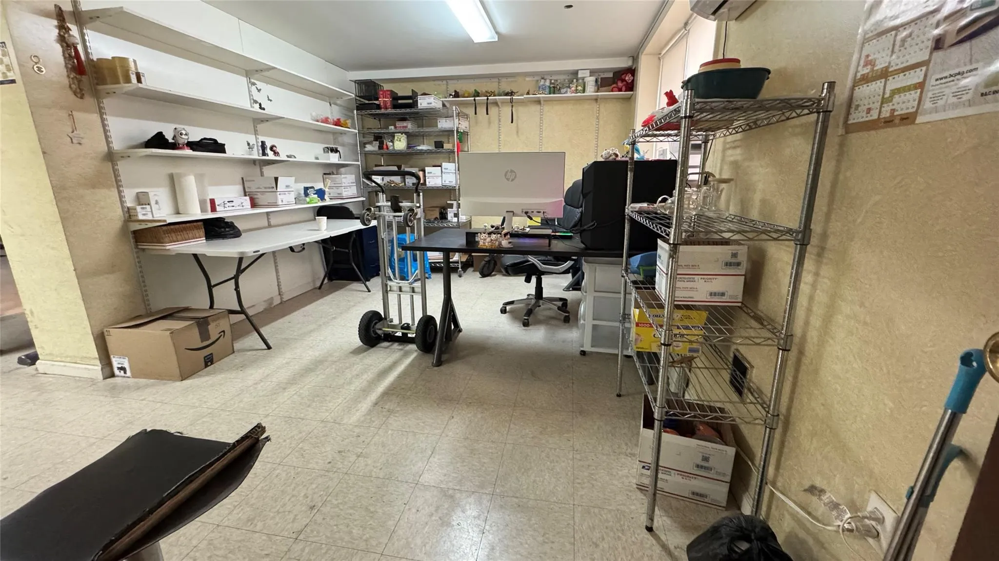Home office with light floors, a textured wall, and an AC wall unit Home office with light floors, a textured wall, and an AC wall unit