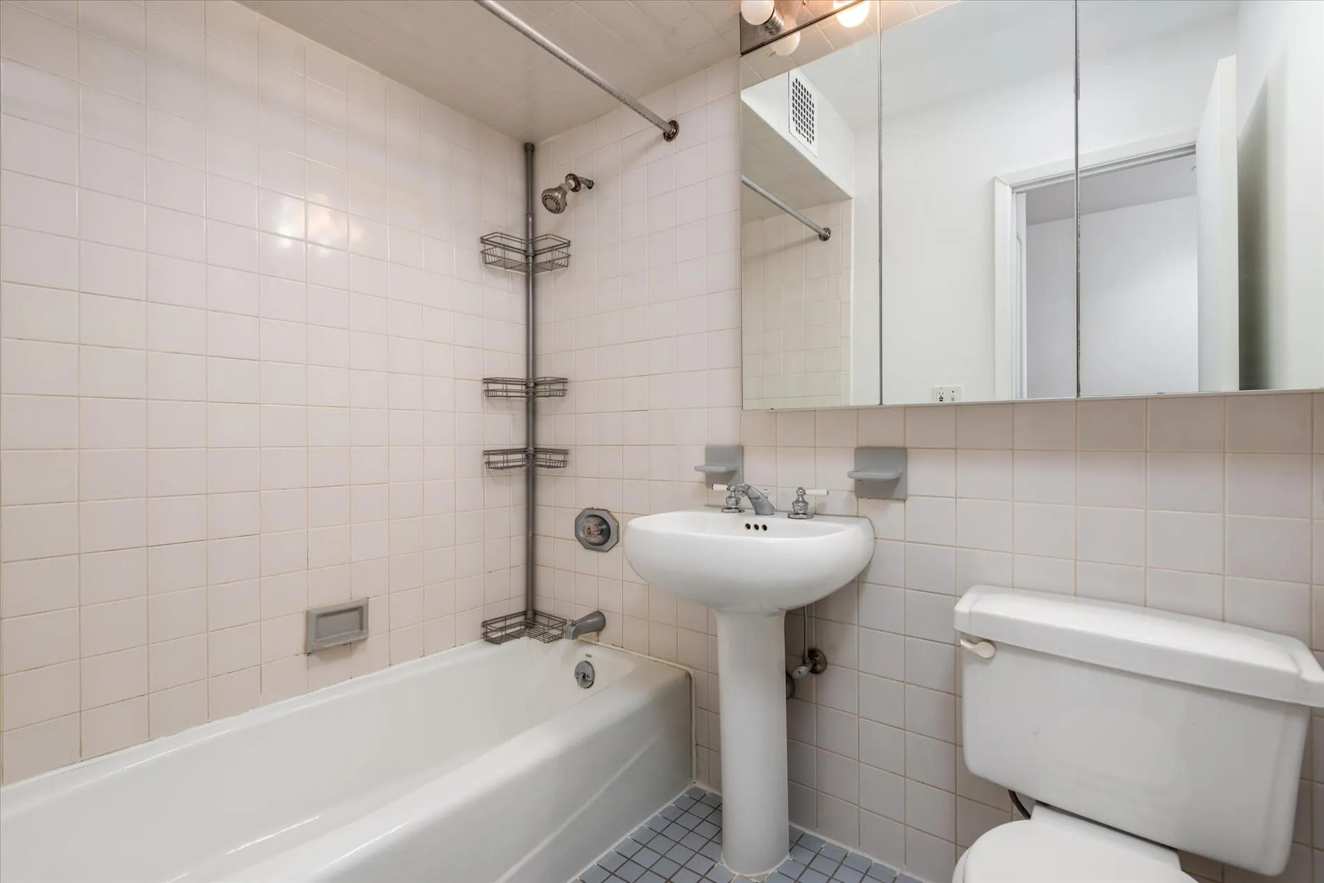 Bathroom featuring tile walls, bathing tub / shower combination, tile patterned flooring, and decorative backsplash Bathroom featuring tile walls, bathing tub / shower combination, tile patterned flooring, and decorative backsplash