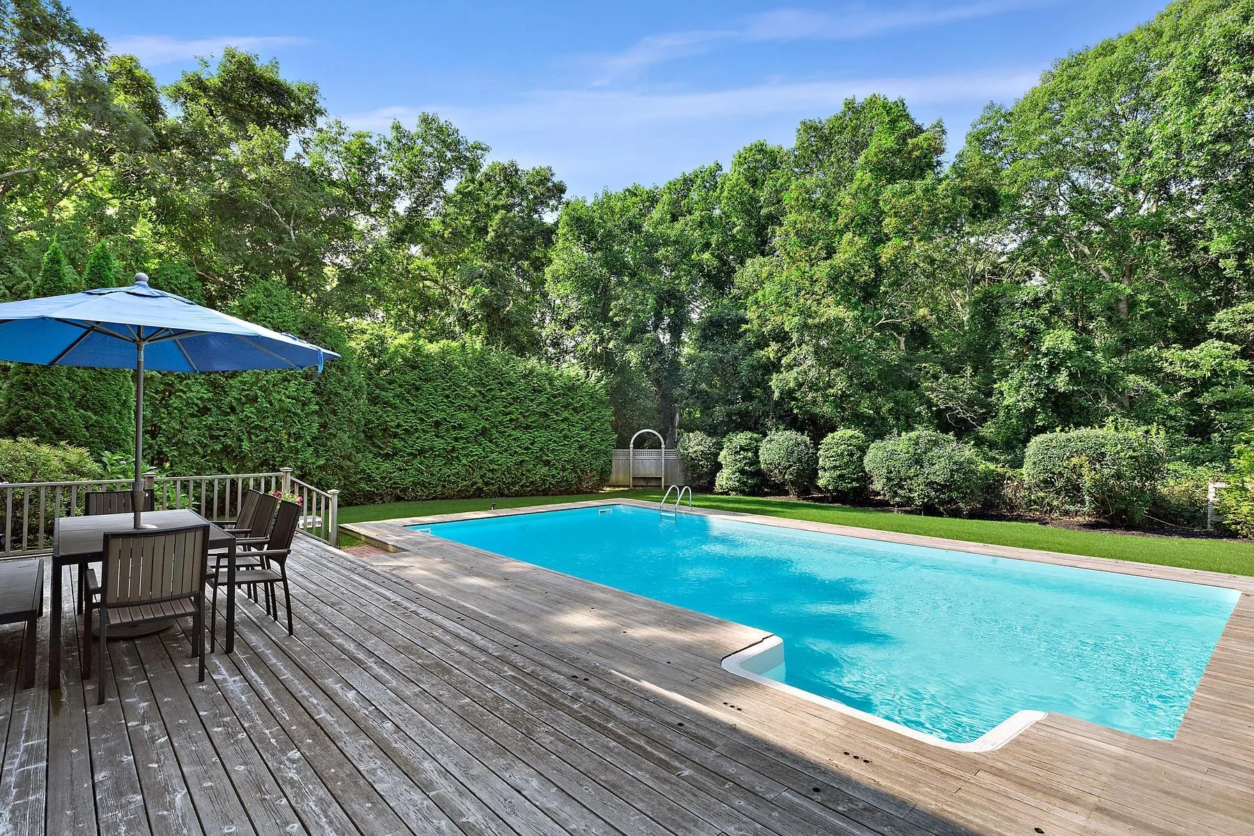 View of swimming pool featuring a wooden deck and outdoor dining space View of swimming pool featuring a wooden deck and outdoor dining space