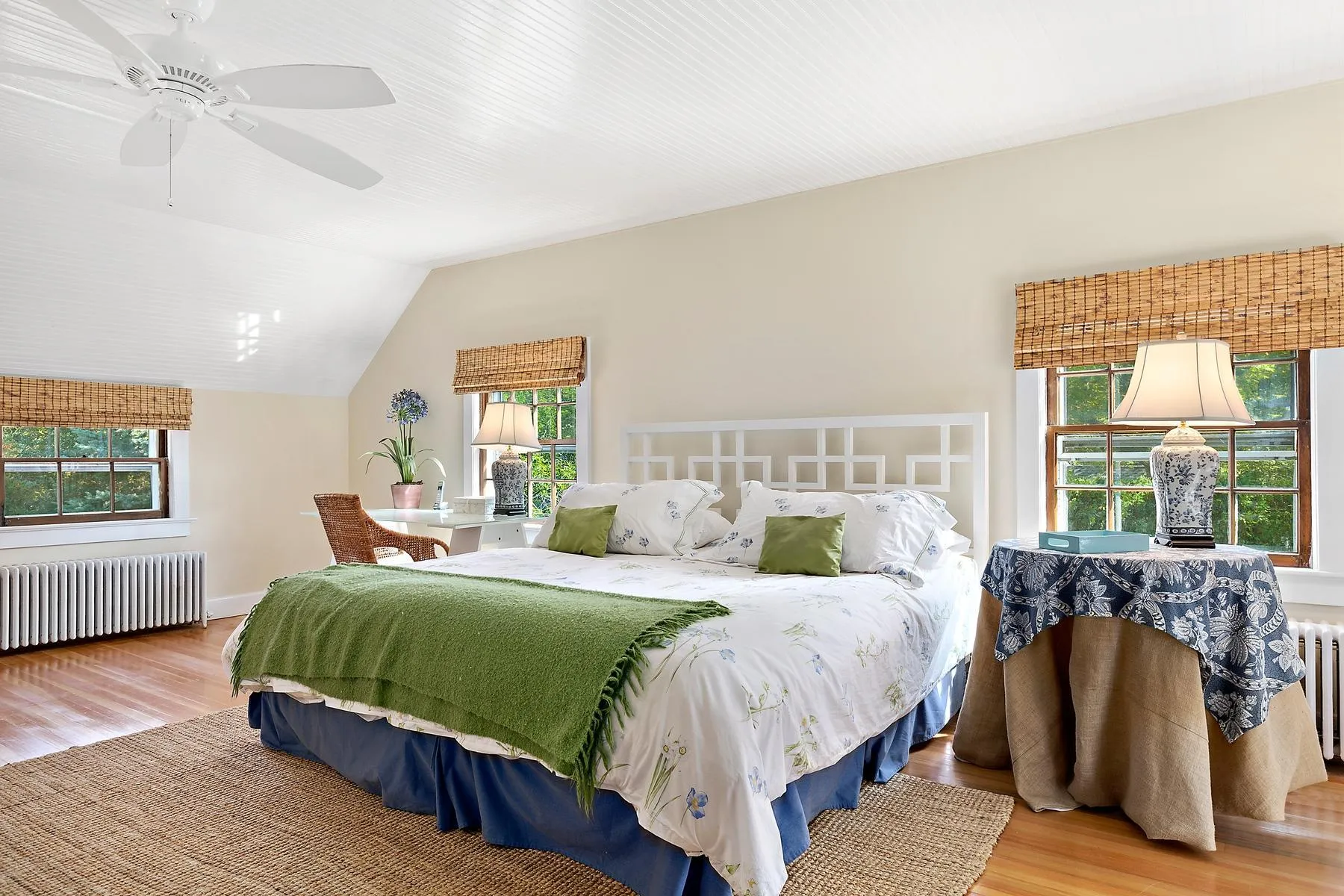 Bedroom featuring radiator, wood finished floors, lofted ceiling, and ceiling fan Bedroom featuring radiator, wood finished floors, lofted ceiling, and ceiling fan